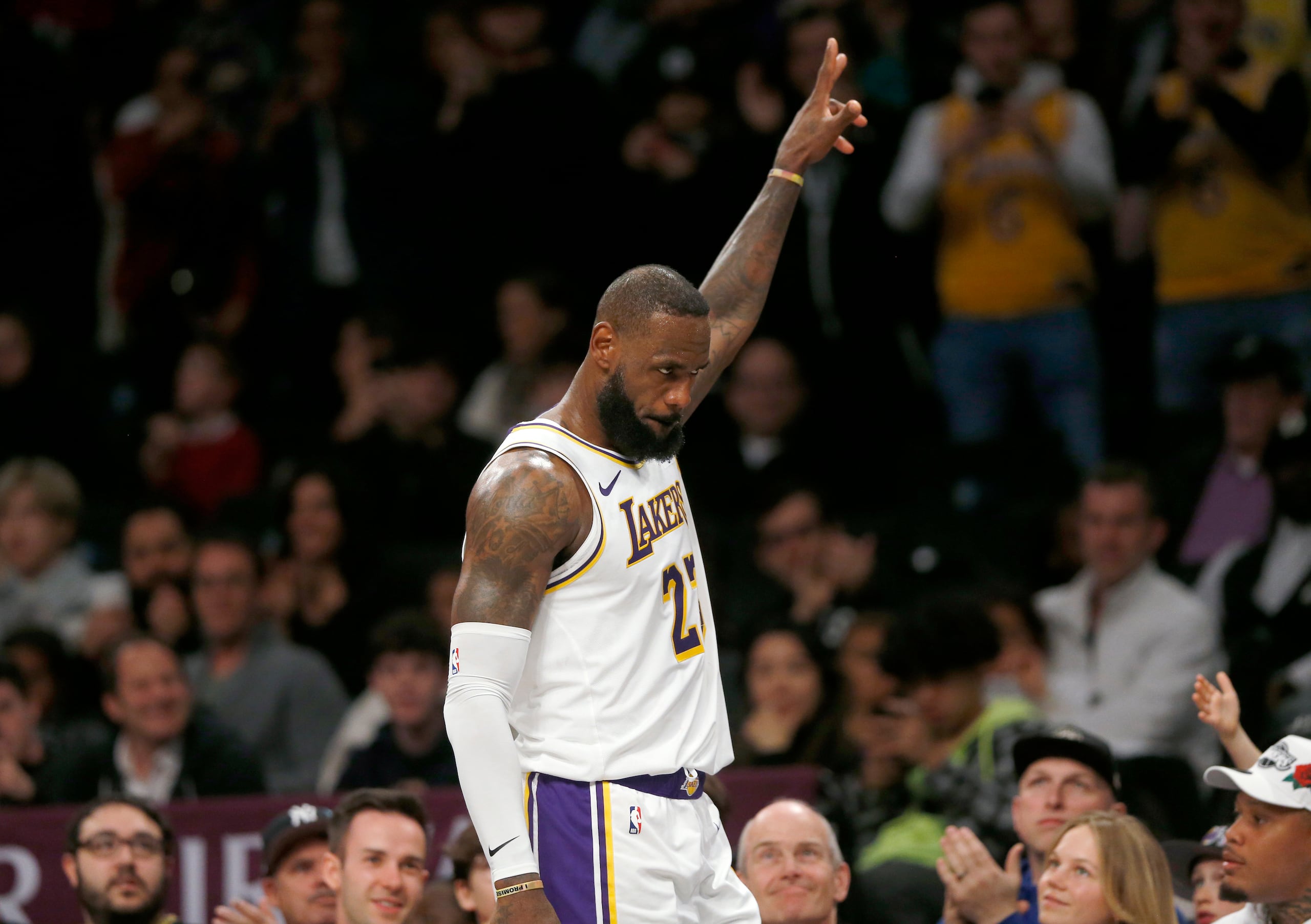 El alero de los Lakers de Los Ánngeles LeBron James recibe el reconocimiento de la fanaticada mientras se dirige al banquillo en los instantes finales del último período del juego de baloncesto ante los Nets de Brooklyn, el domingo 31 de marzo de 2024, en Nueva York. (AP Foto/John Munson)