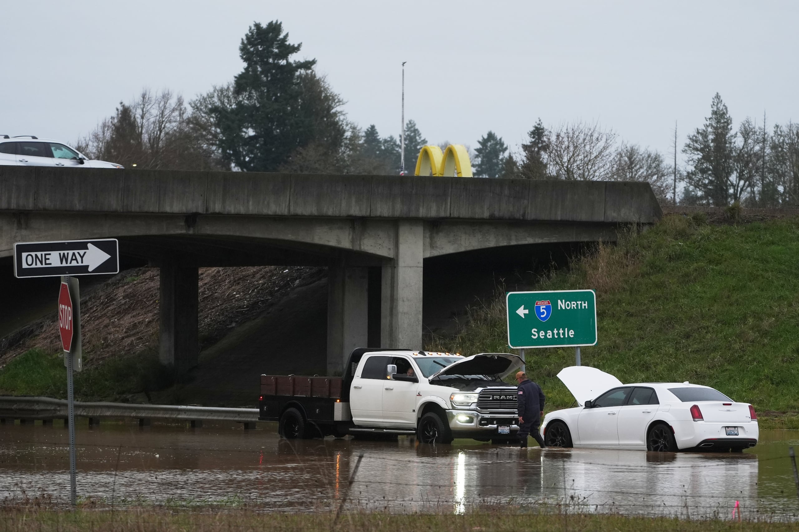 Un hombre revisa un auto atrapado en una inundación tras intensas lluvias, el martes 9 de diciembre de 2025, en Napavine, Washington. (AP Foto/Lindsey Wasson)