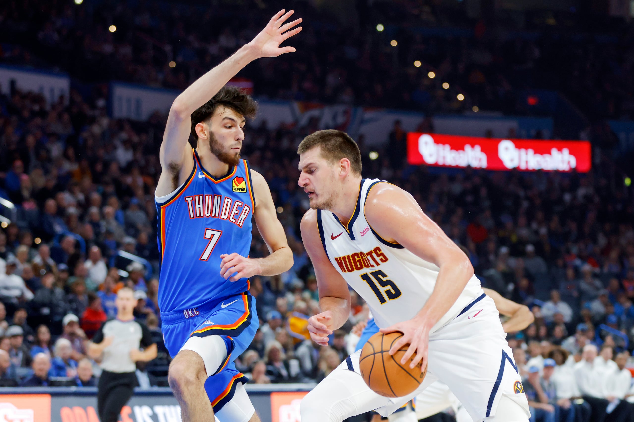 El pivot de los Nuggets de Denver Nikola Jokic avanza hacia la canasta frente al alero del Thunder de Oklahoma City Chet Holmgren en el encuentro de la NBA el domingo.