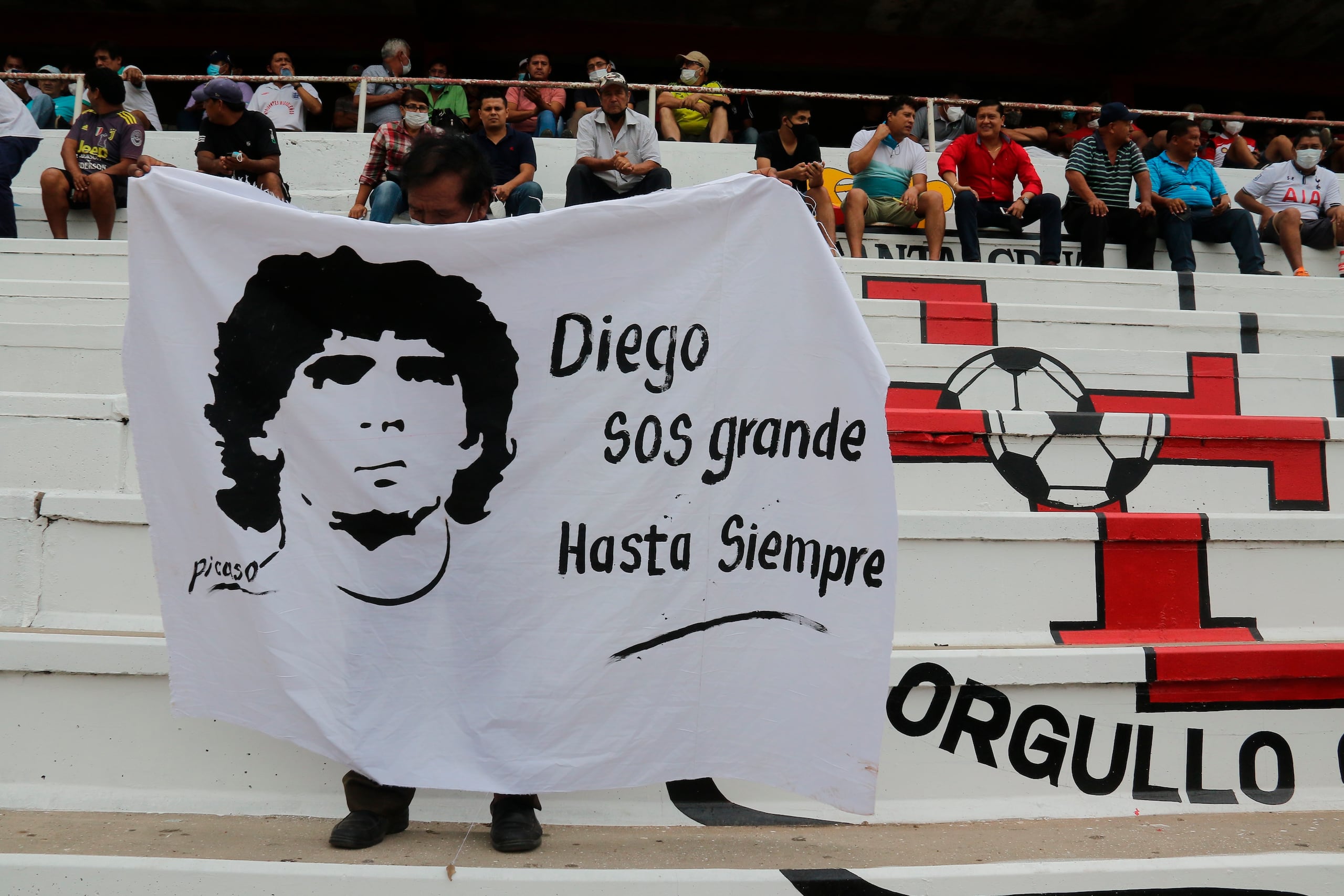Un aficionado sostiene una pancarta con la imagen del fallecido Diego Armando Maradona.