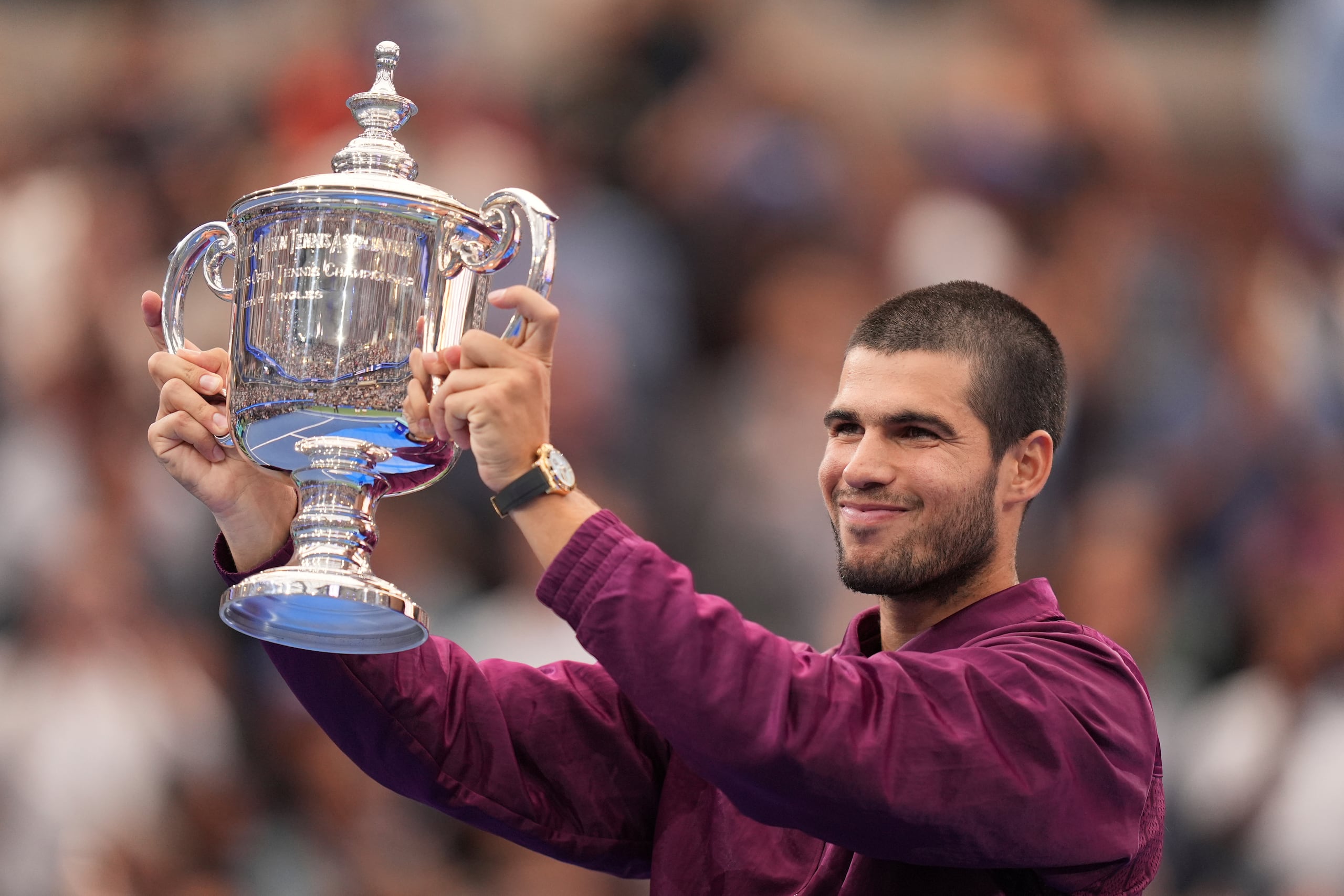 Carlos Alcaraz alza el trofeo de campeón tras derrotar a Jannik Sinner en la final masculina del Abierto de Estados Unidos.