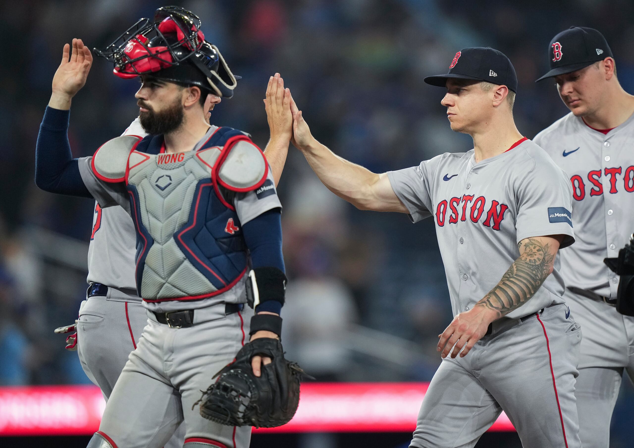 El bateador designado de los Red Sox,, Tyler O'Neill, segundo desde la derecha, celebra con sus compañeros de equipo después de derrotar a los Blue Jays en nueve entradas en Toronto.