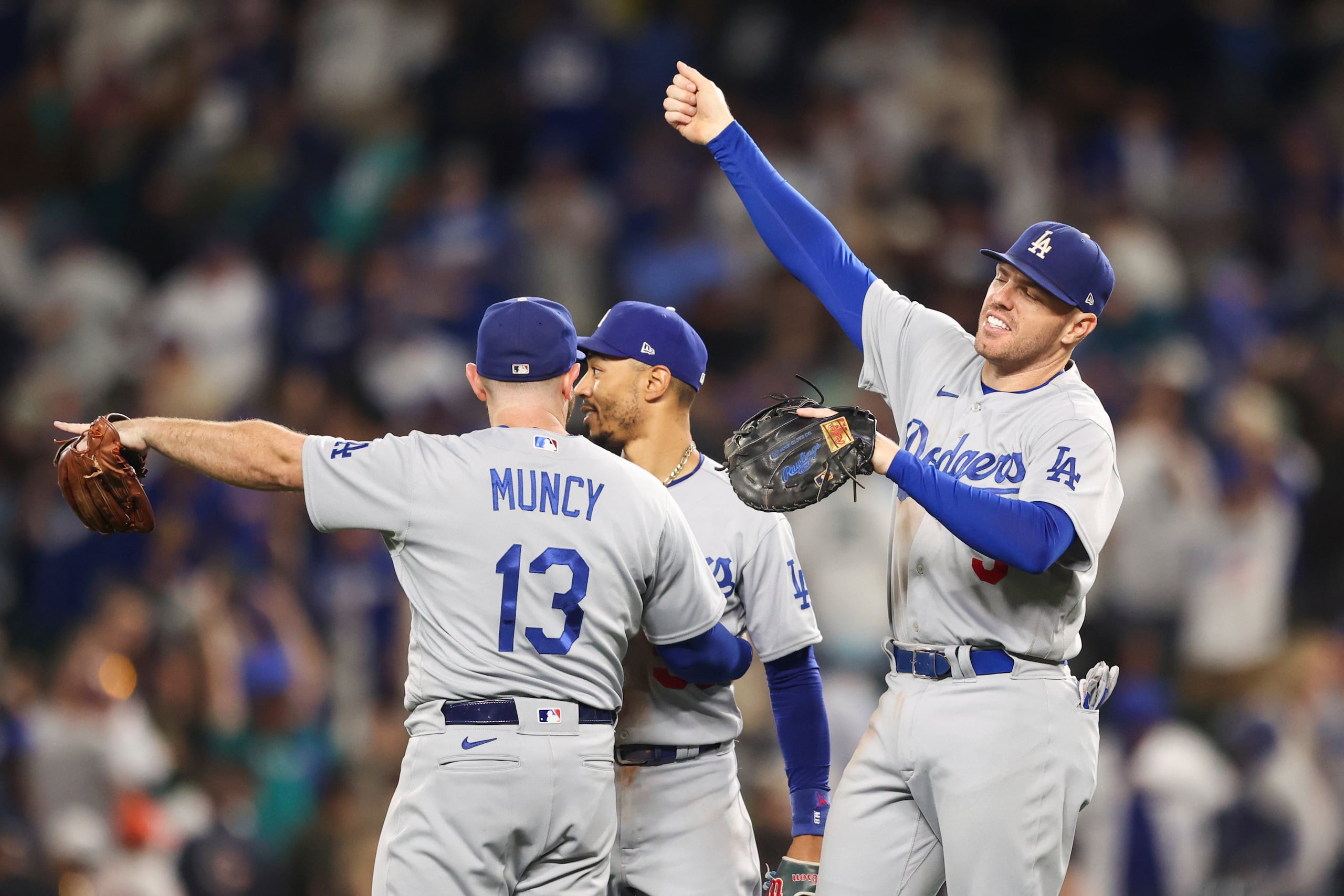 Freddie Freeman, ala derecha, celebra con Max Muncy y Mookie Betts al cierre del partido.