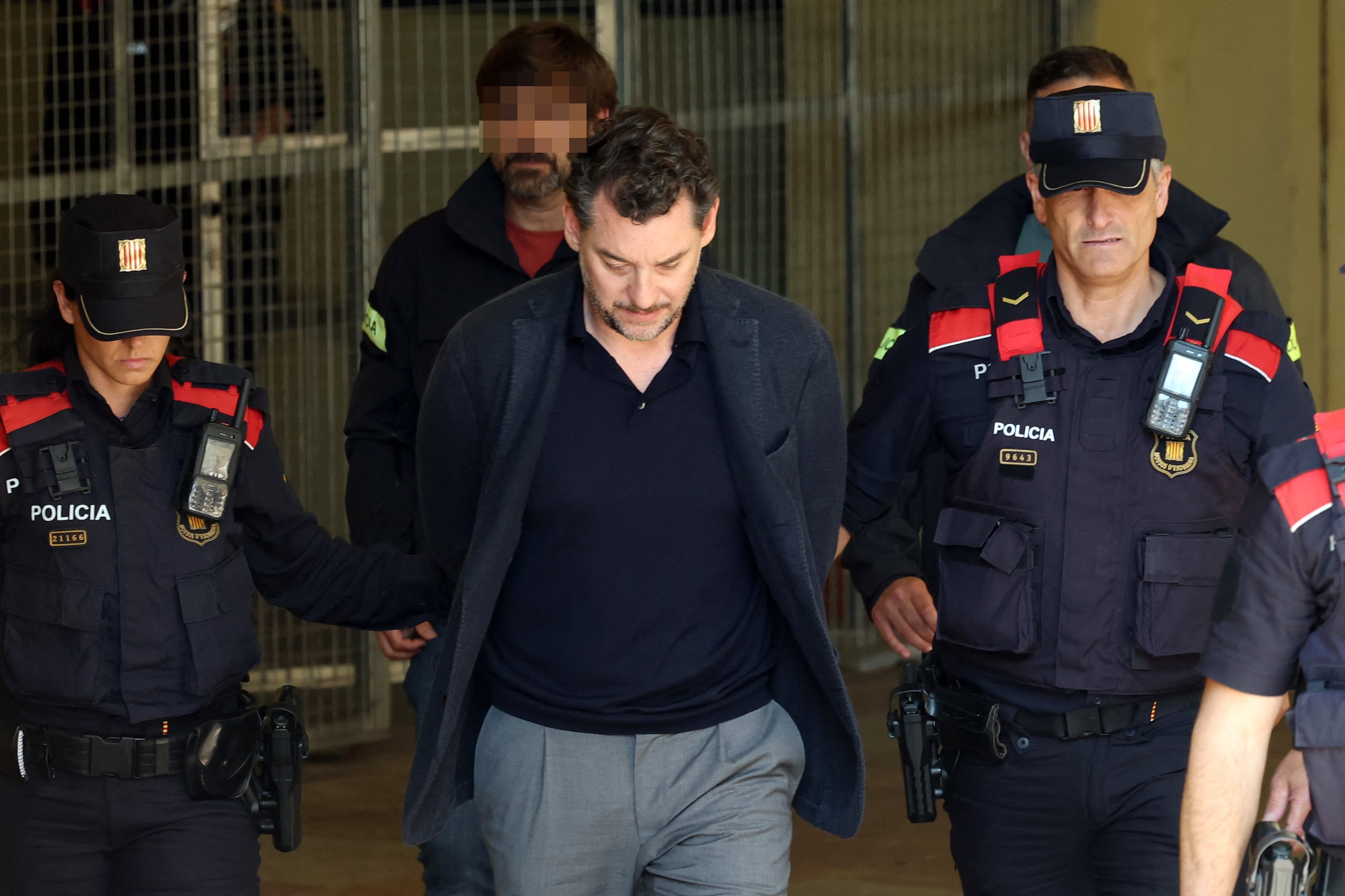 Agentes de la Policía regional de Cataluña escoltan a Jonathan Andic, hijo de Isak Andic, fundador de la marca de moda española Mango, a su llegada a un tribunal en Martorell, cerca de Barcelona, tras su arresto el 19 de mayo de 2026.