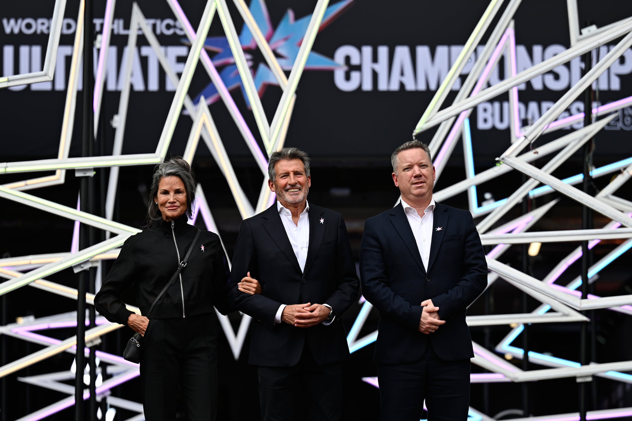 El presidente de World Athletics, Sebastian Coe (en el centro), el ministro del Interior de Hungría, Gabor Posfai (a la derecha), y Diane Richie llegan por la alfombra roja durante la inauguración oficial del World Athletics Ultimate Championship en Budapest, Hungría, el jueves 10 de septiembre de 2026. (Foto AP/Denes Erdos)