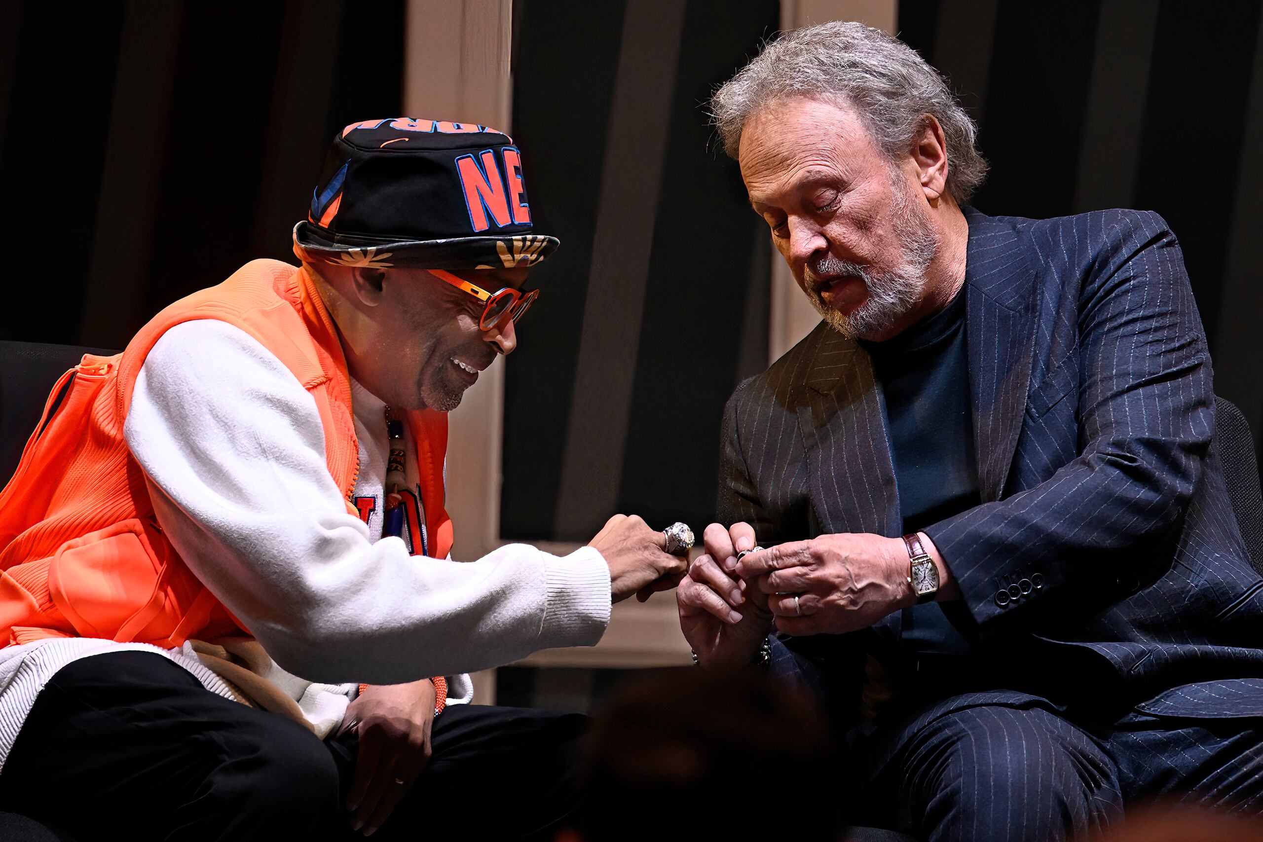El director de cine Spike Lee y el comediante Billy Crystal comparan sortijas luego de ser honrados como superfanáticos del baloncesto.