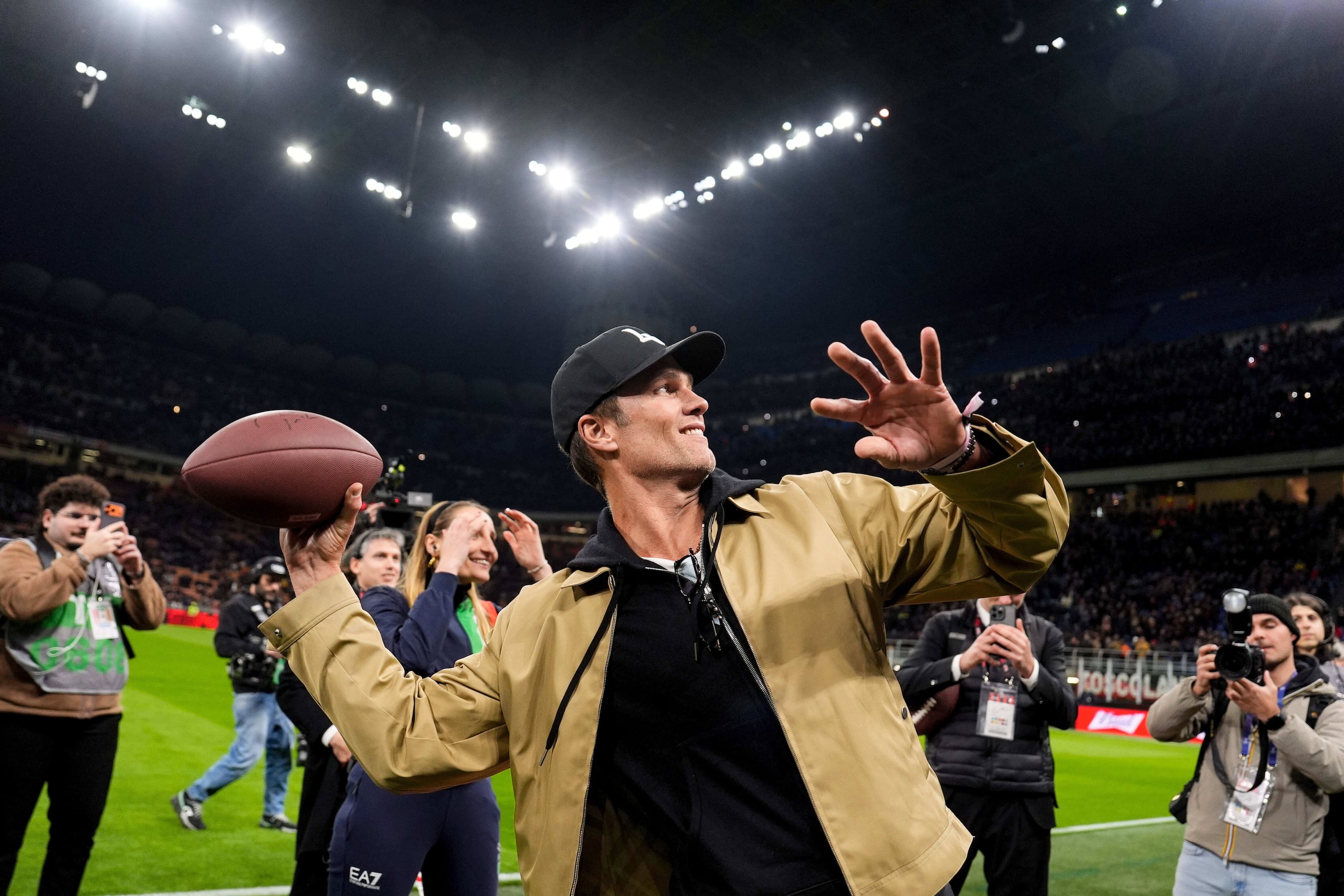 Tom Brady, exjugador de fútbol americano de la NFL, lanza el balón antes del partido de la Serie A entre el AC Milan y el Como, el miércoles 18 de febrero de 2026, en Milán, Italia. (Fabio Ferrari/LaPresse vía AP)