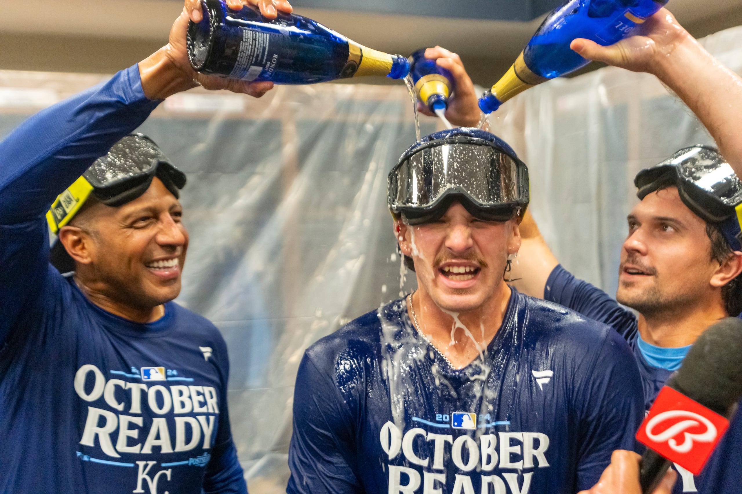 Bobby Witt Jr. (centro), de los Reales de Kansas  City, es empapado en champaña tras la clasificación a los playoffs pese a una derrota ante los Bravos de Atlanta, el viernes 27 de septiembre de 2024 (AP Foto/Jason Allen)
