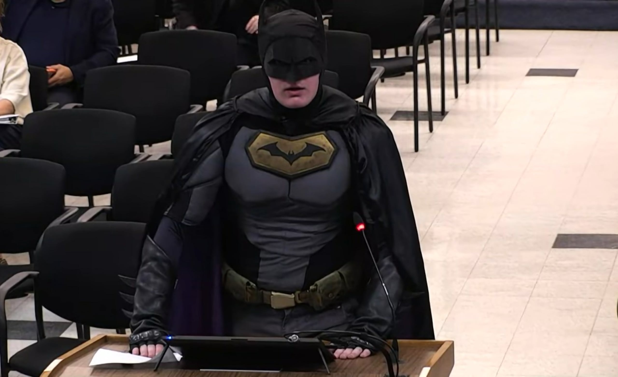 Disfrazado como el hombre murciélago, el ciudadano tomó el podio y tronó contra los funcionarios de la ciudad por su actitud de cooperación incondicional con el gobierno.