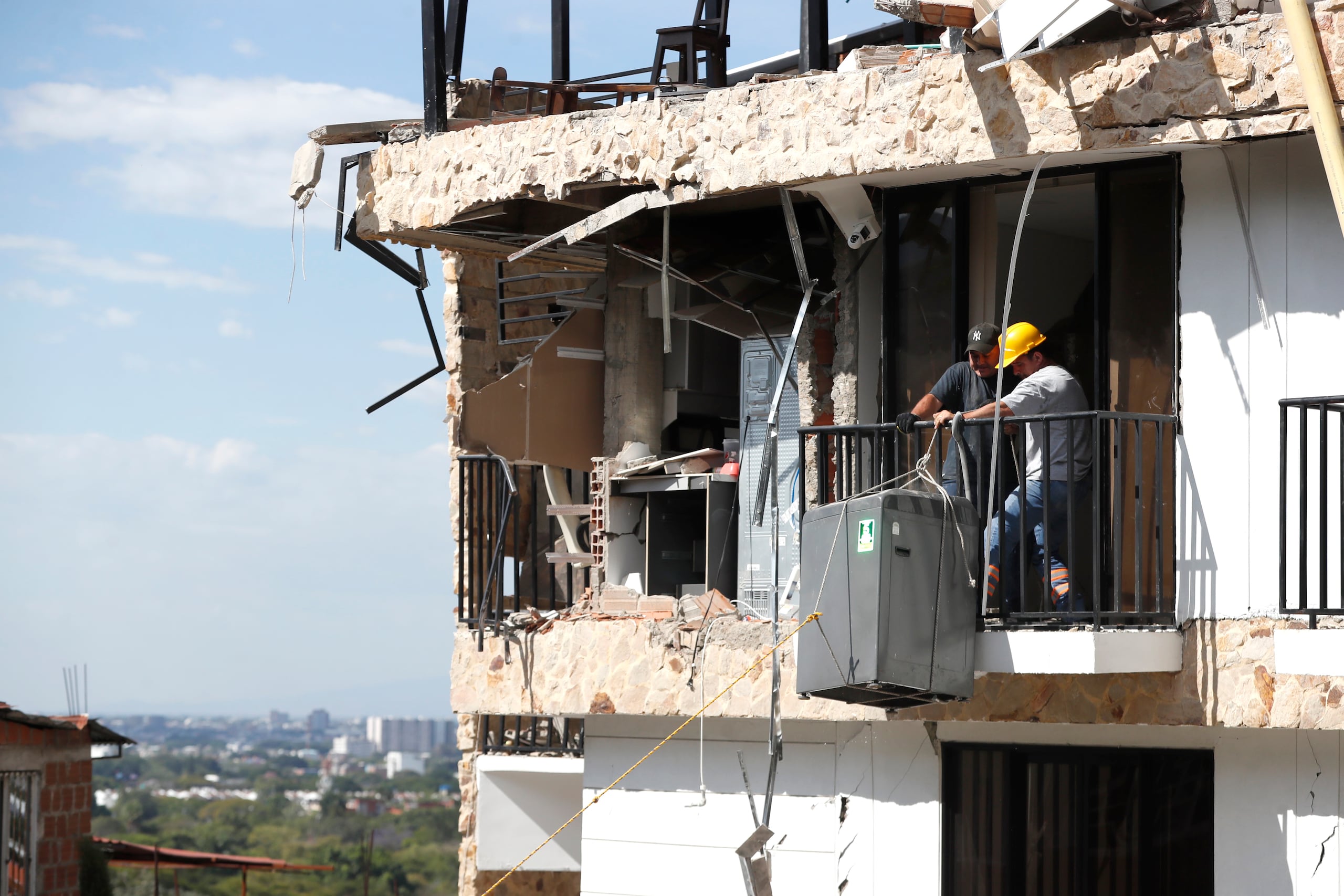 Personas sacan un electrodoméstico este jueves de una edificación afectada por el terremoto de magnitud 7,4 en Cali (Colombia). EFE/ Ernesto Guzmán
