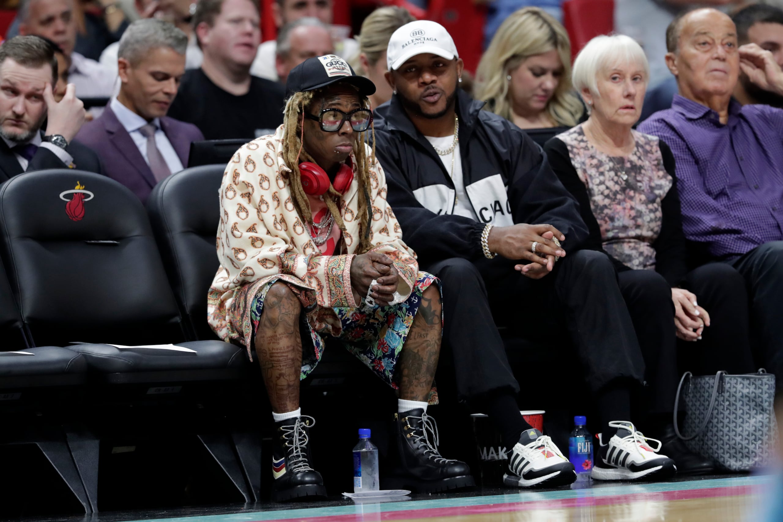 El rapero Lil Wayne, izquierda, en la segunda mitad del partido de la NBA entre los Lakers de Los Angeles y el Heat de Miami el 13 de diciembre de 2019, en Miami.