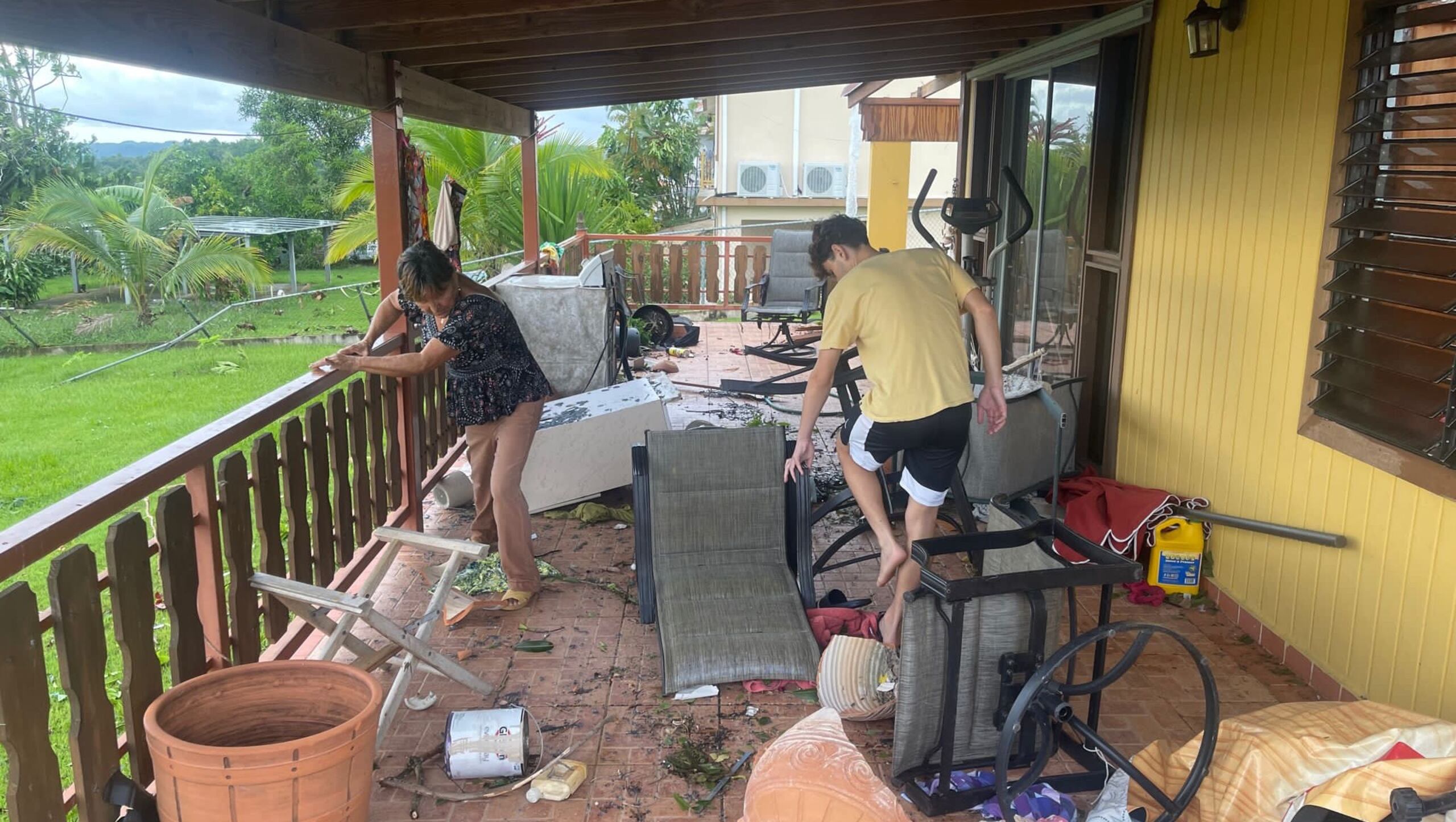 Familiares realizan labores de limpieza en la residencia de Eligia Vargas Villanueva en Aguada, que fue afectada por un tornado.