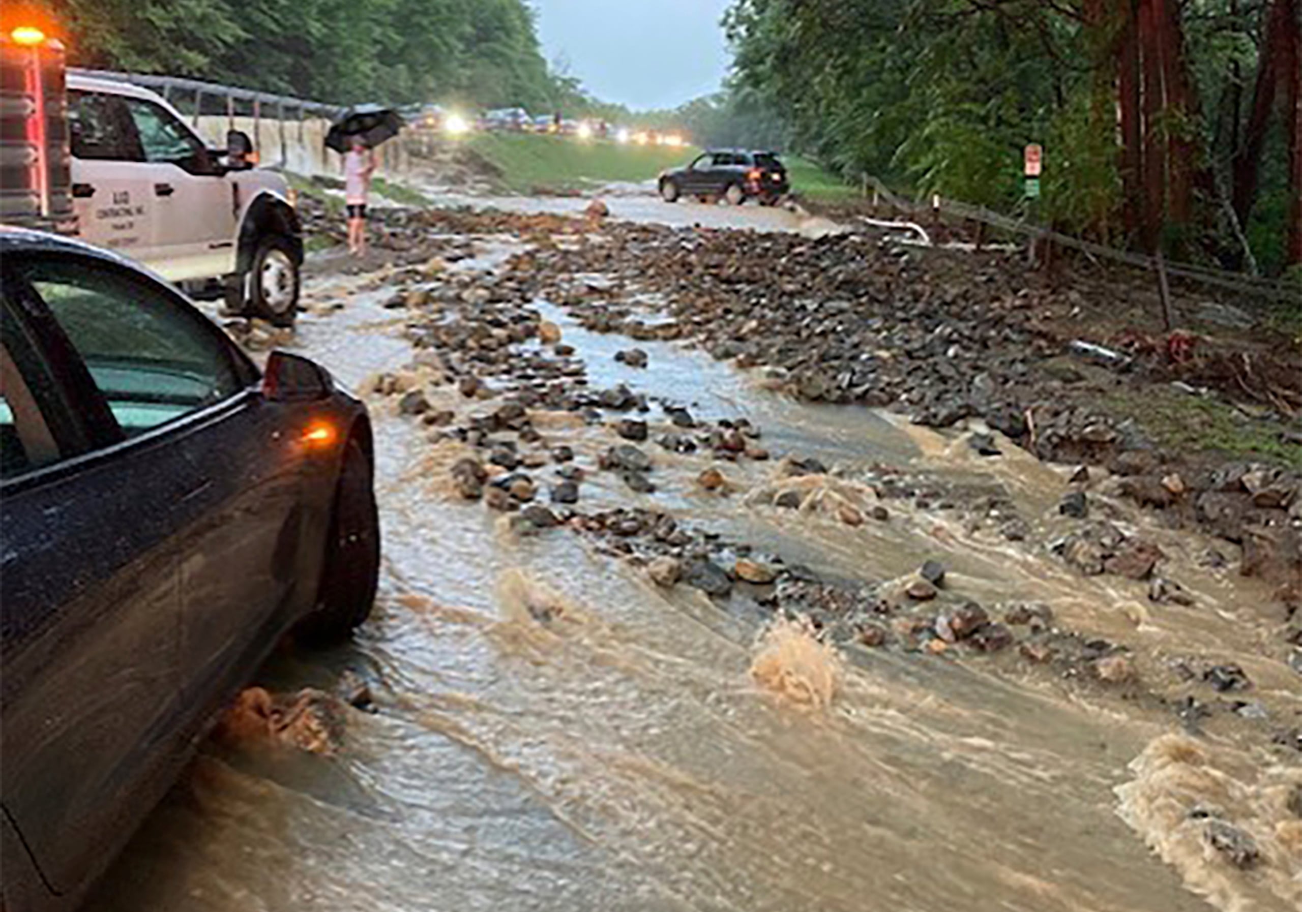 Vehículos detenidos cerca de un tramo de la carretera Palisades inundado y dañado por el agua junto al puente Bear Mountain, el domingo en el condado Orange, Nueva York.