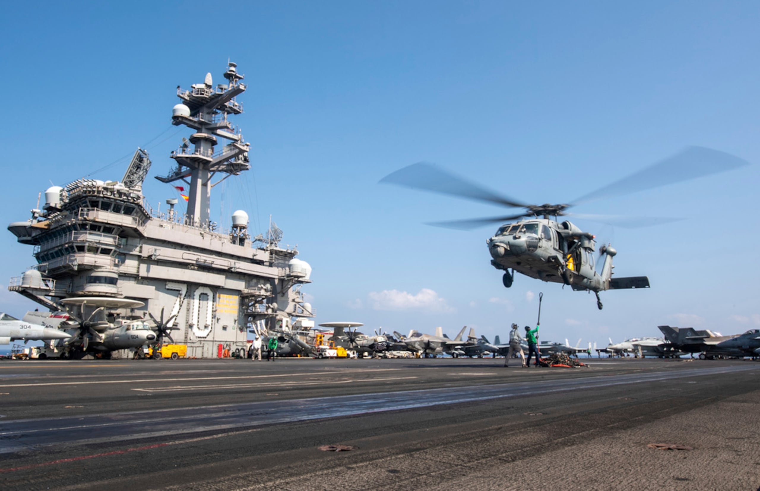 Esta fotografía publicada por la Marina de los Estados Unidos muestra un helicóptero MH-60S Sea Hawk suspendido sobre el portaaviones USS Carl Vinson mientras opera en el Medio Oriente el 12 de abril de 2025.