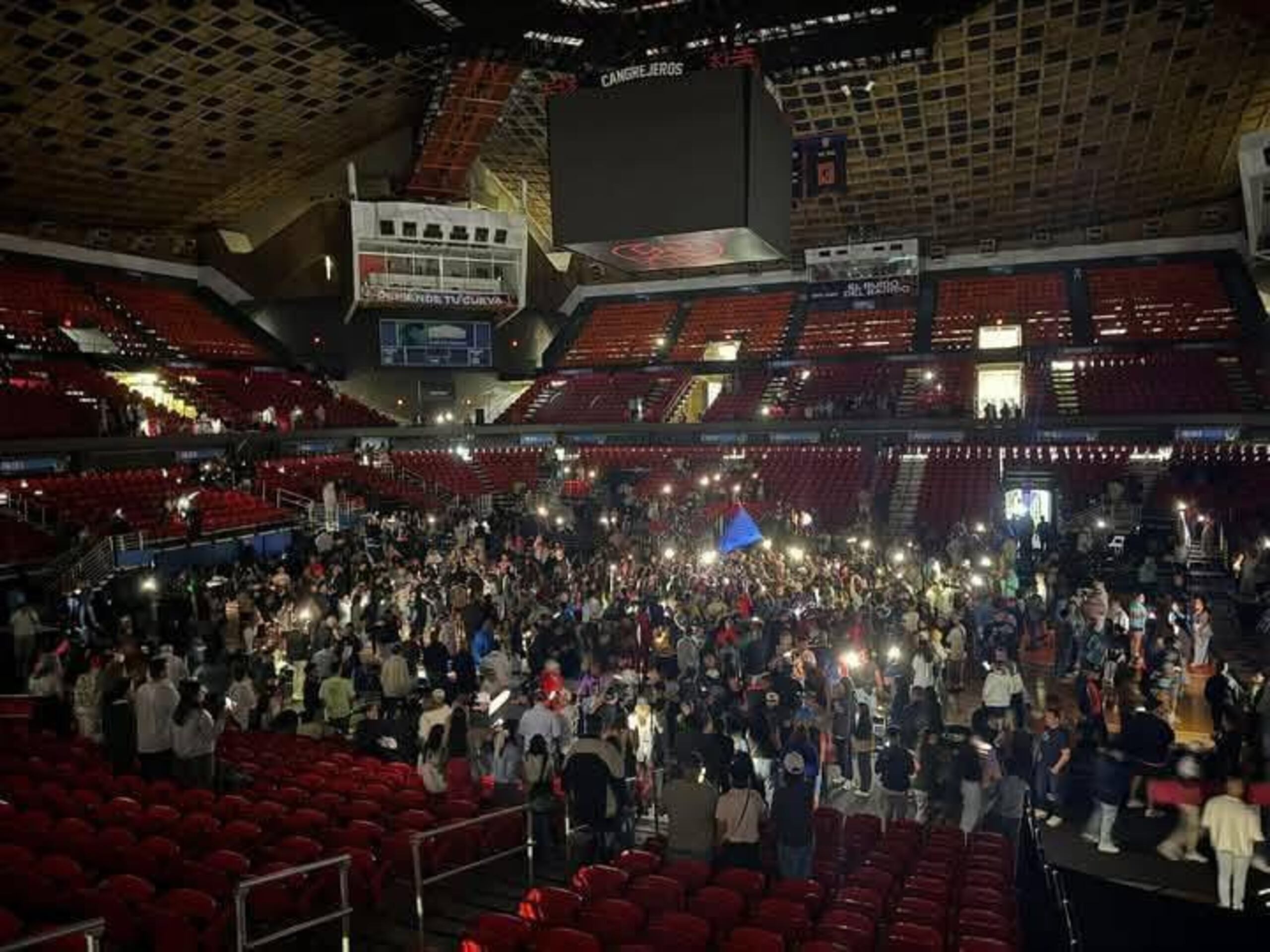 La fanaticada de las Criollas de Caguas celebra ante un Coliseo Roberto Clemente a oscuras.