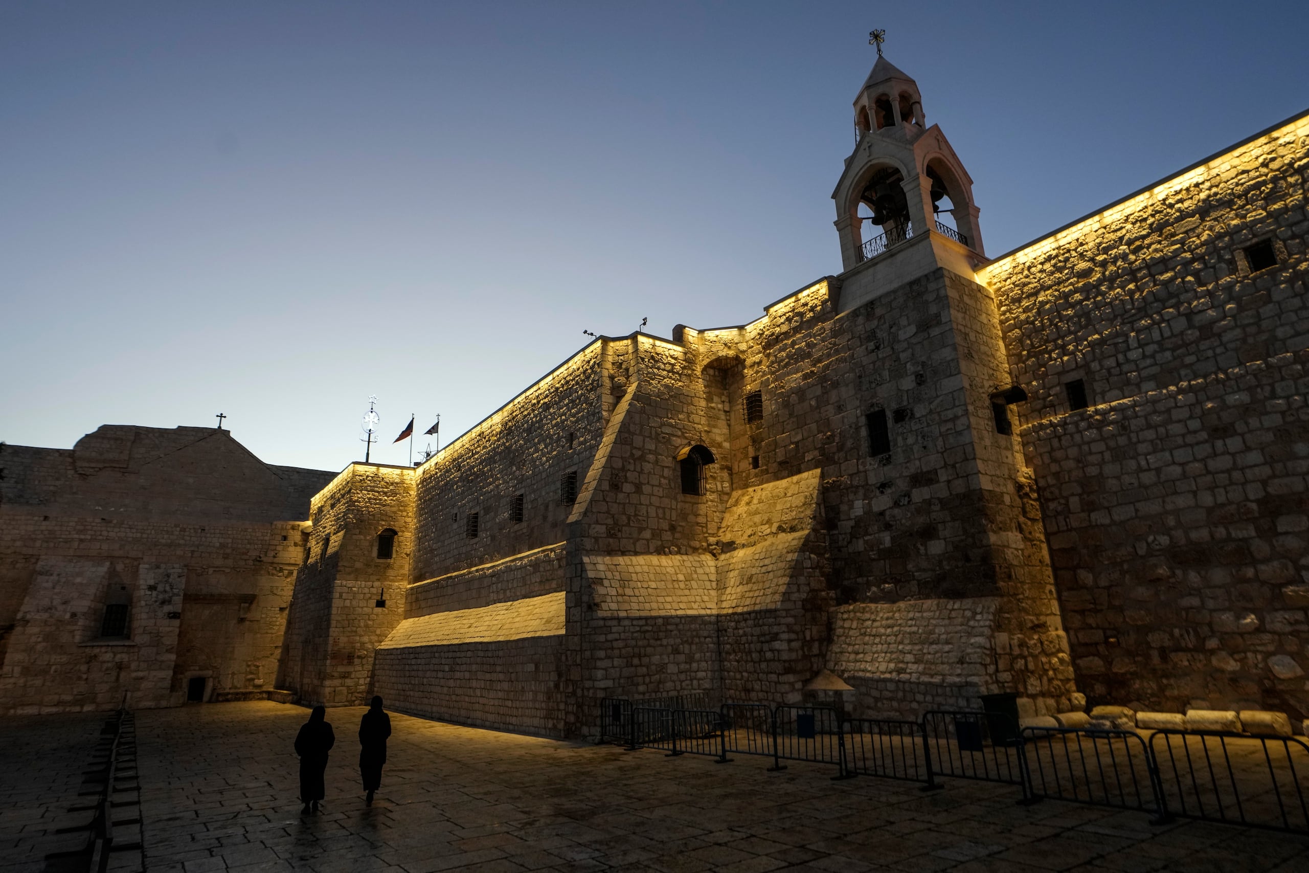 Unas monjas caminan junto a la Iglesia de la Natividad, tradicionalmente considerada el lugar de nacimiento de Jesús, en la Víspera de Navidad, en la ciudad cisjordana de Belén, el martes 24 de diciembre de 2024. (AP foto/Matias Delacroix)