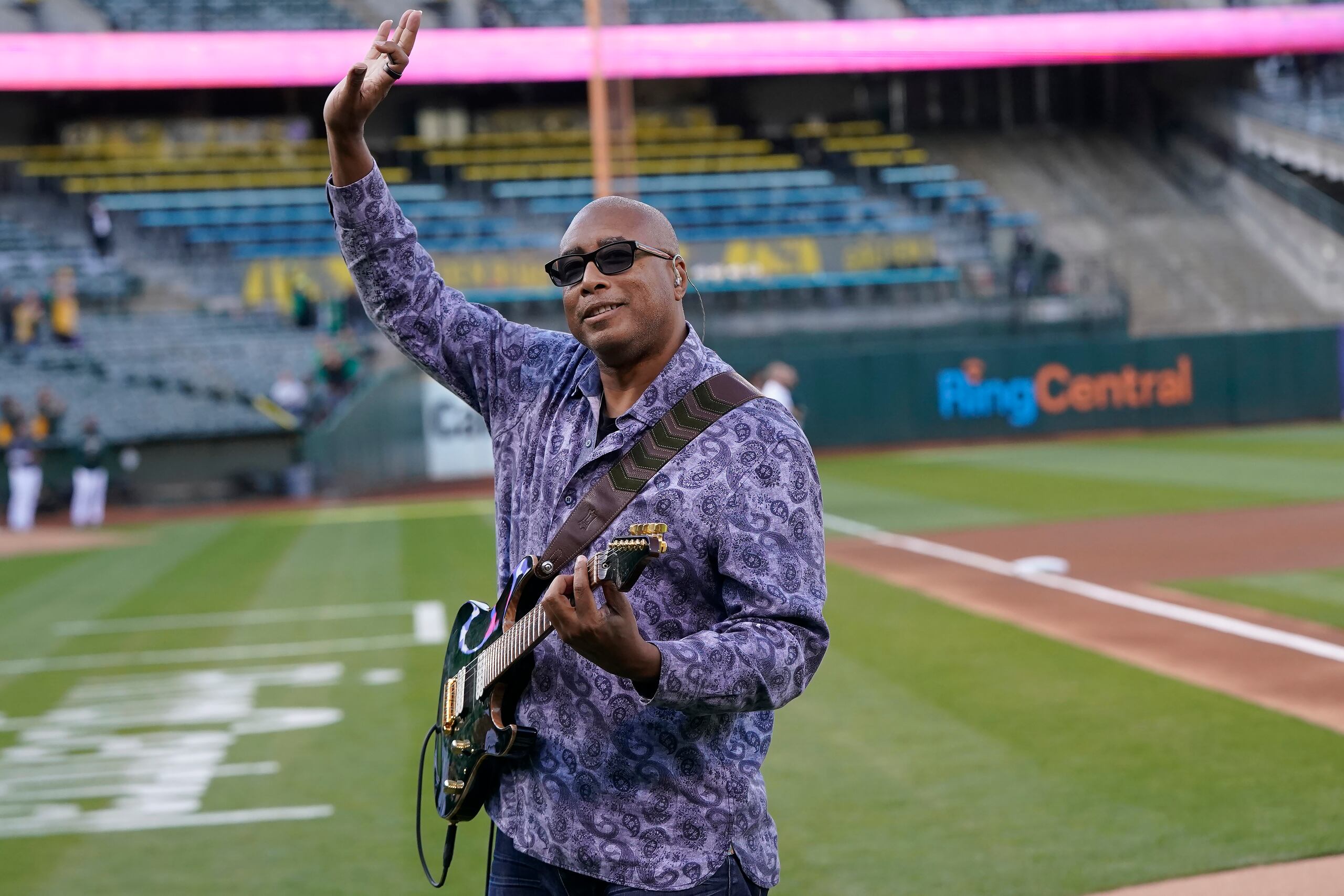 Bernie Williams saluda después de tocar el himno nacional de Estados Unidos antes del juego de béisbol entre los Athletics de Oakland y los Twins de Minnesota, en Oakland, California, el 16 de mayo de 2022.