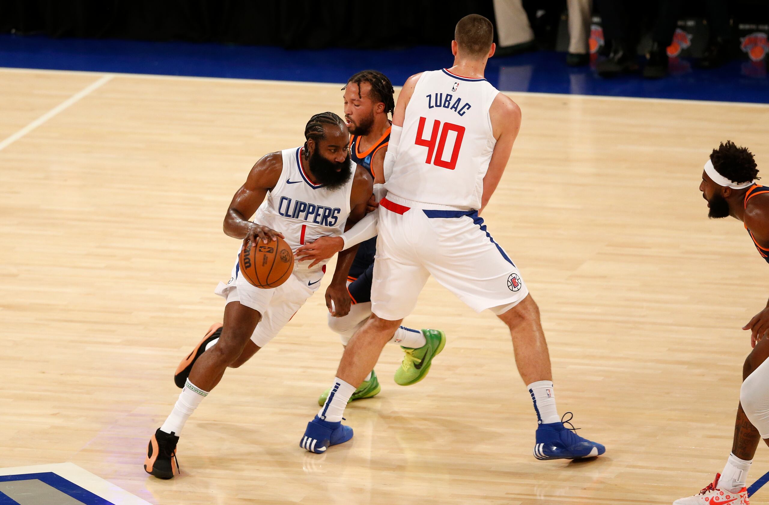 James Harden busca sacar provecho a una cortina que le hizo su compañero Ivica Zubac (40) para intentar huir de una defensa de Jalen Brunson.