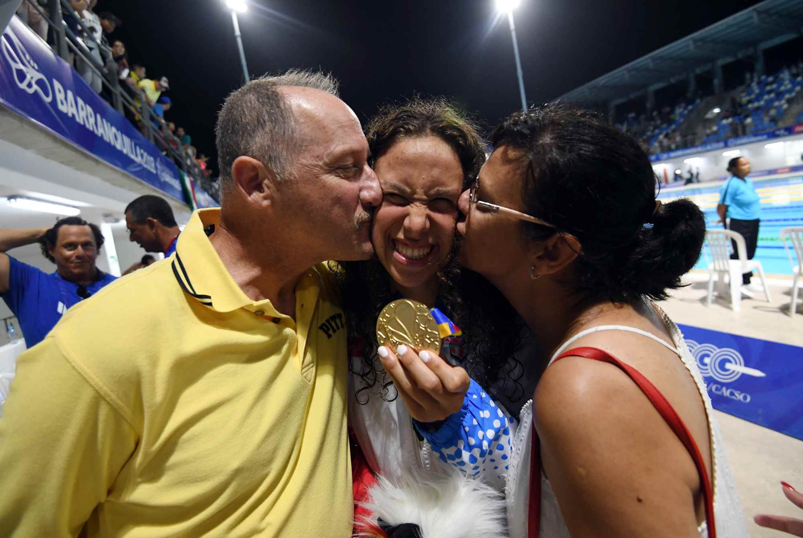 Kristen Romano ganó el lunes una medalla de oro en el evento de los 400 metros combinados individual. En la foto, la joven es besada por sus padre Mike y su madre Brenda.