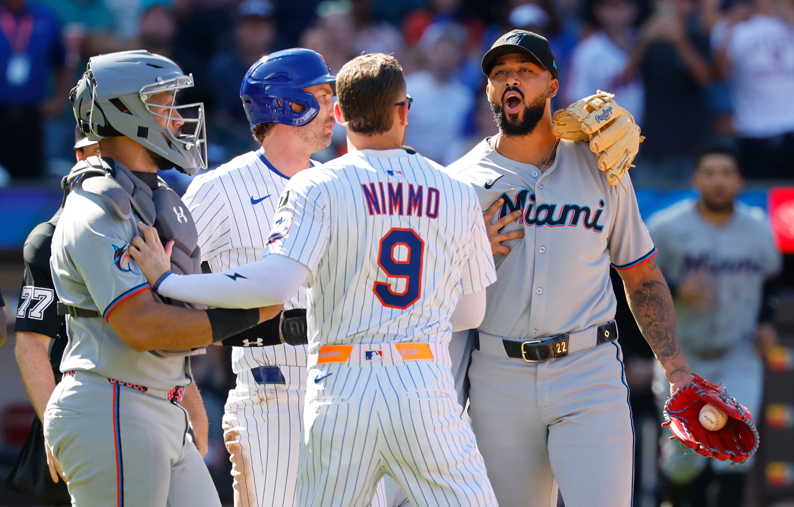 Brandon Nimmo (9), de los Mets de Nueva York, habla con el lanzador de los Marlins de Miami, Sandy Alcántara. derecha, después de que un lanzamiento golpeara a Mark Vientos, de los Mets, durante la séptima entrada.