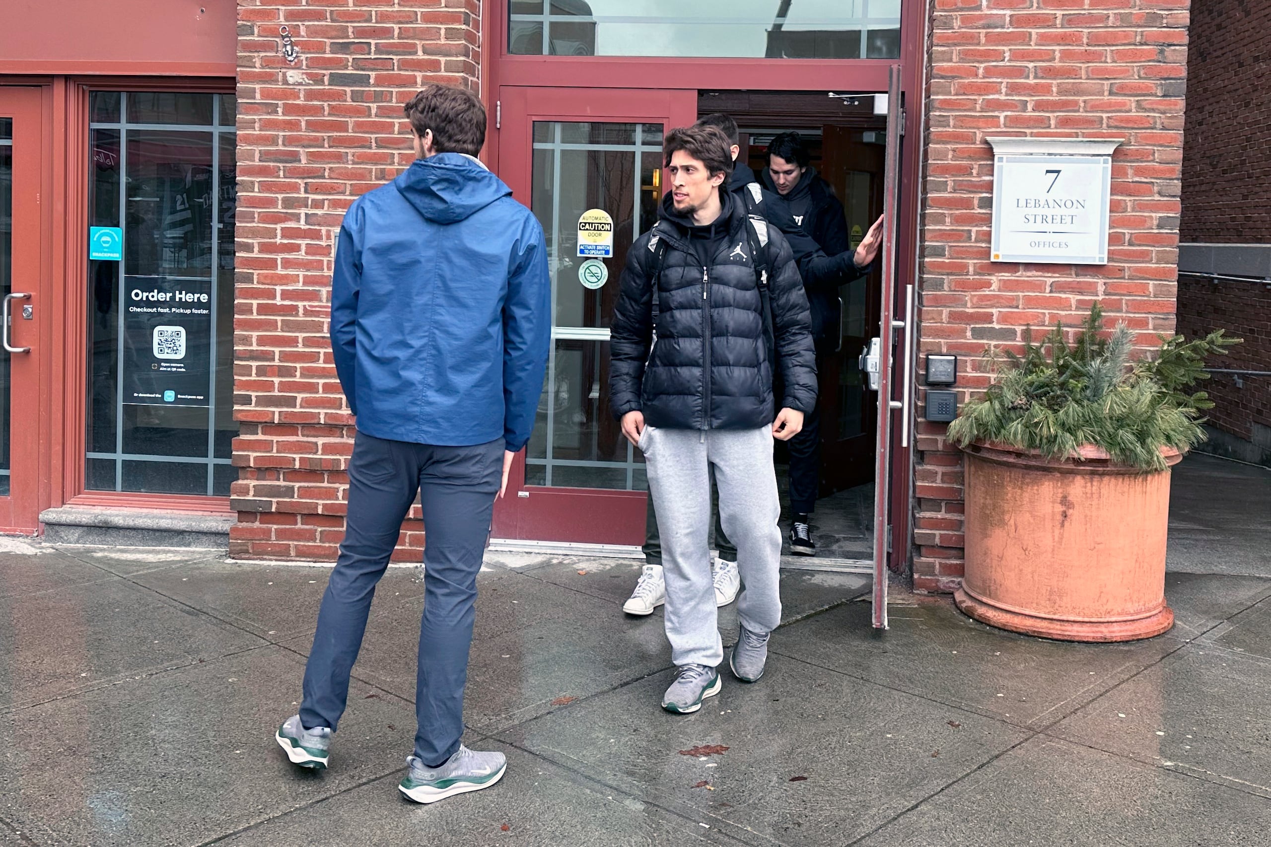 Un grupo de jugadores de basquetbol de Dartmouth salen del lugar donde votaron a favor de sindicalizarse.
