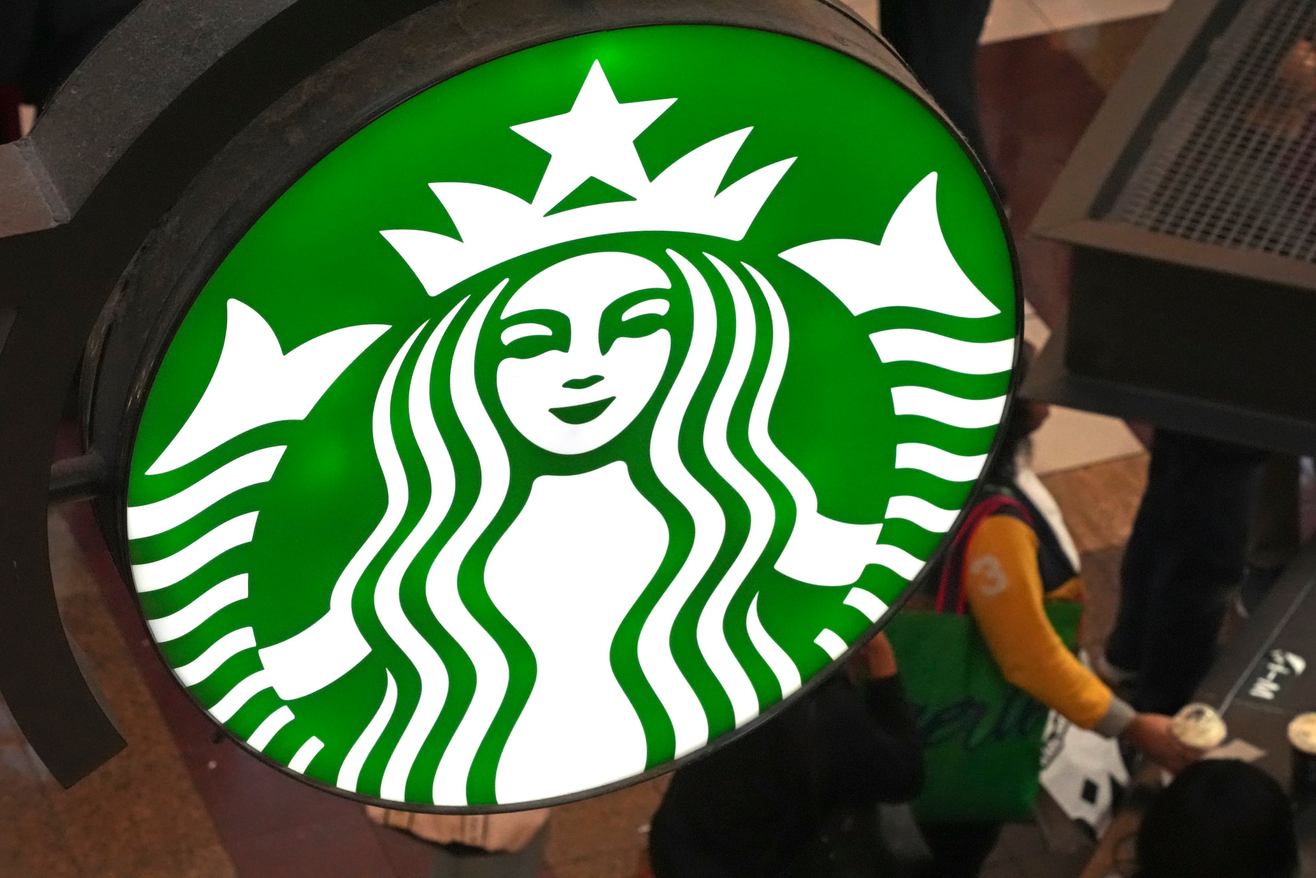 ARCHIVO – El logotipo de Starbucks en la fila de clientes del Black Friday en un quiosco de Starbucks en la Walden Galleria en Buffalo, Nueva York, el viernes 29 de noviembre de 2024. (AP Foto/Gene J. Puskar)