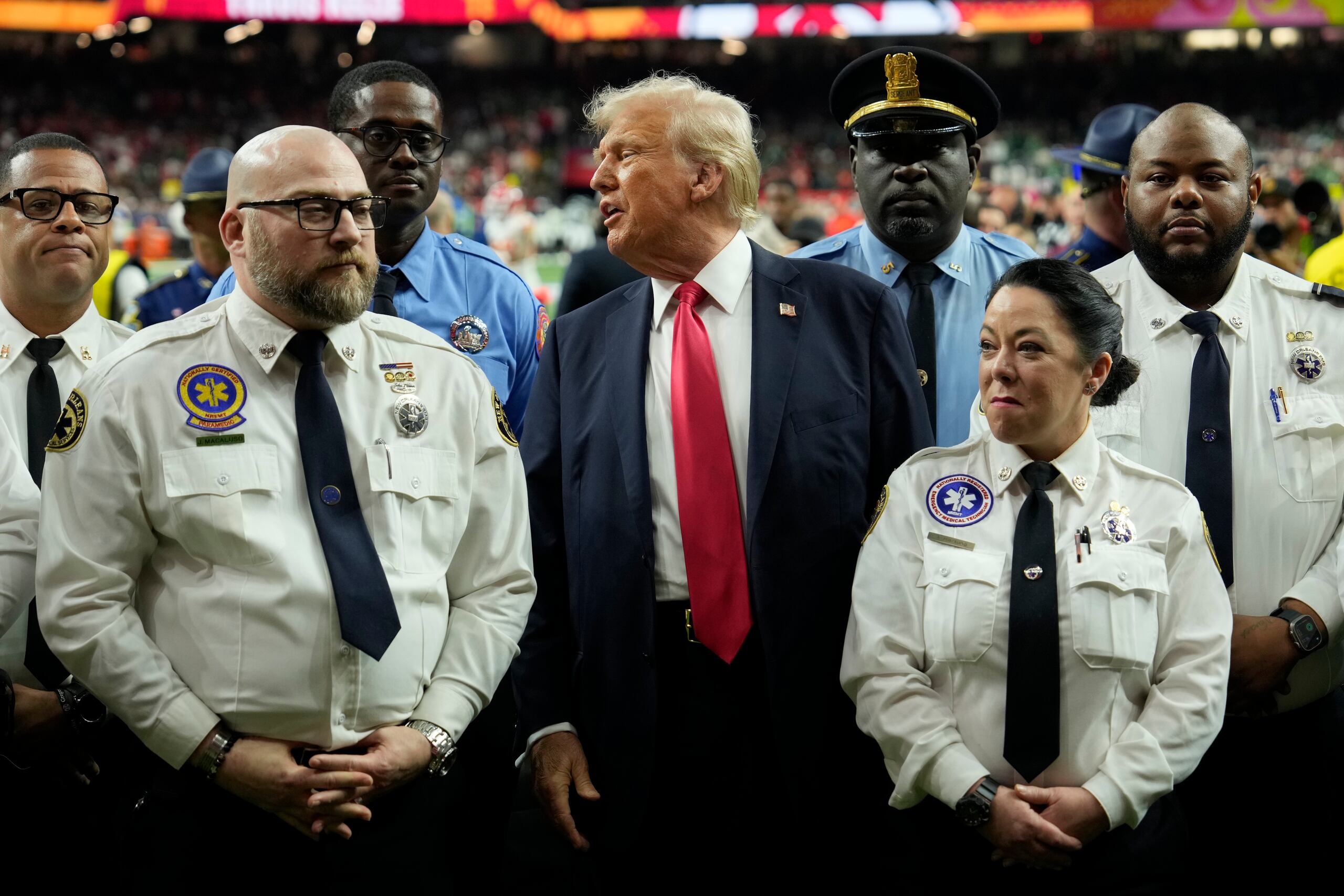 Donald Trump posa con policías y bomberos de Nueva Orleans antes del inicio del partido.