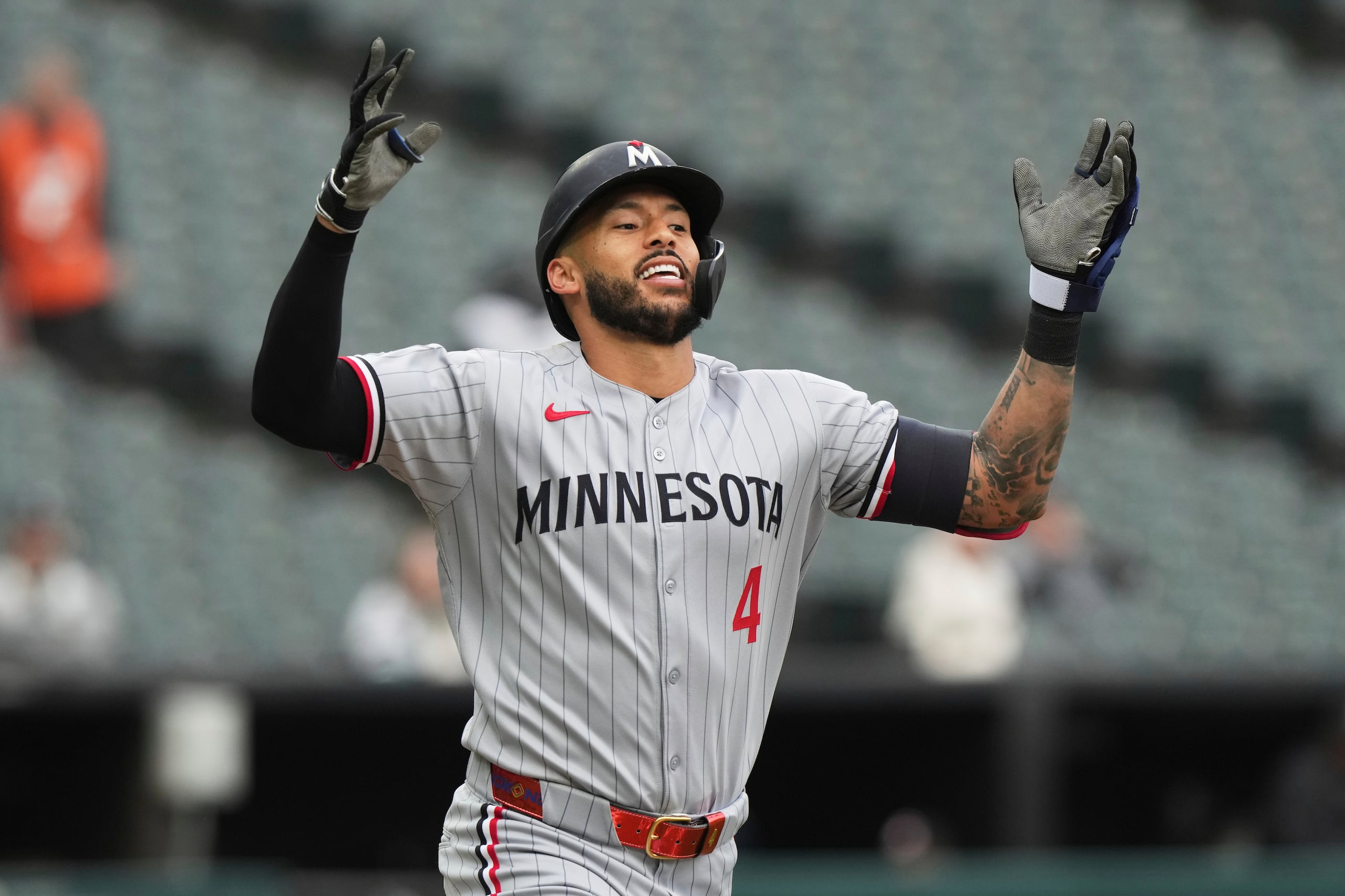 Carlos Correa, de los Mellizos de Minnesota, celebra mientras corre a primera después de batear un sencillo durante la tercera entrada del juego de béisbol de Grandes Ligas frente a Medias Blancas de Chicago. Fue su primer hit de la temporada.