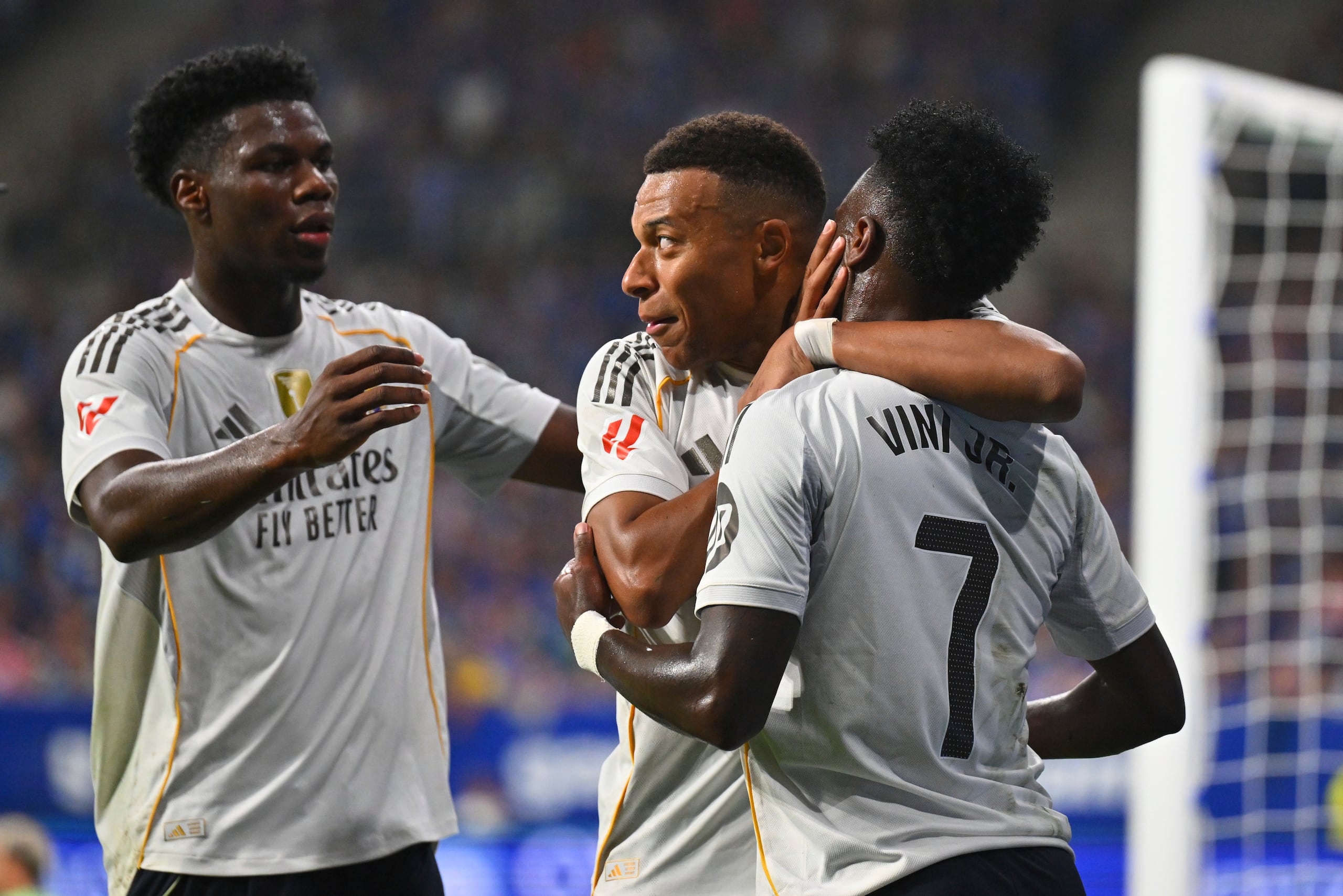Kylian Mbappé, centro, del Real Madrid, es felicitado por sus compañeros Vinícius Junior, derecha, y Aurelien Tchouameni después de marcar el segundo gol de su equipo durante el partido de La Liga española entre Real Oviedo y Real Madrid en el estadio Carlos Tartiere, en Oviedo, España, el domingo 24 de agosto de 2025. (AP Foto/Miguel Oses)