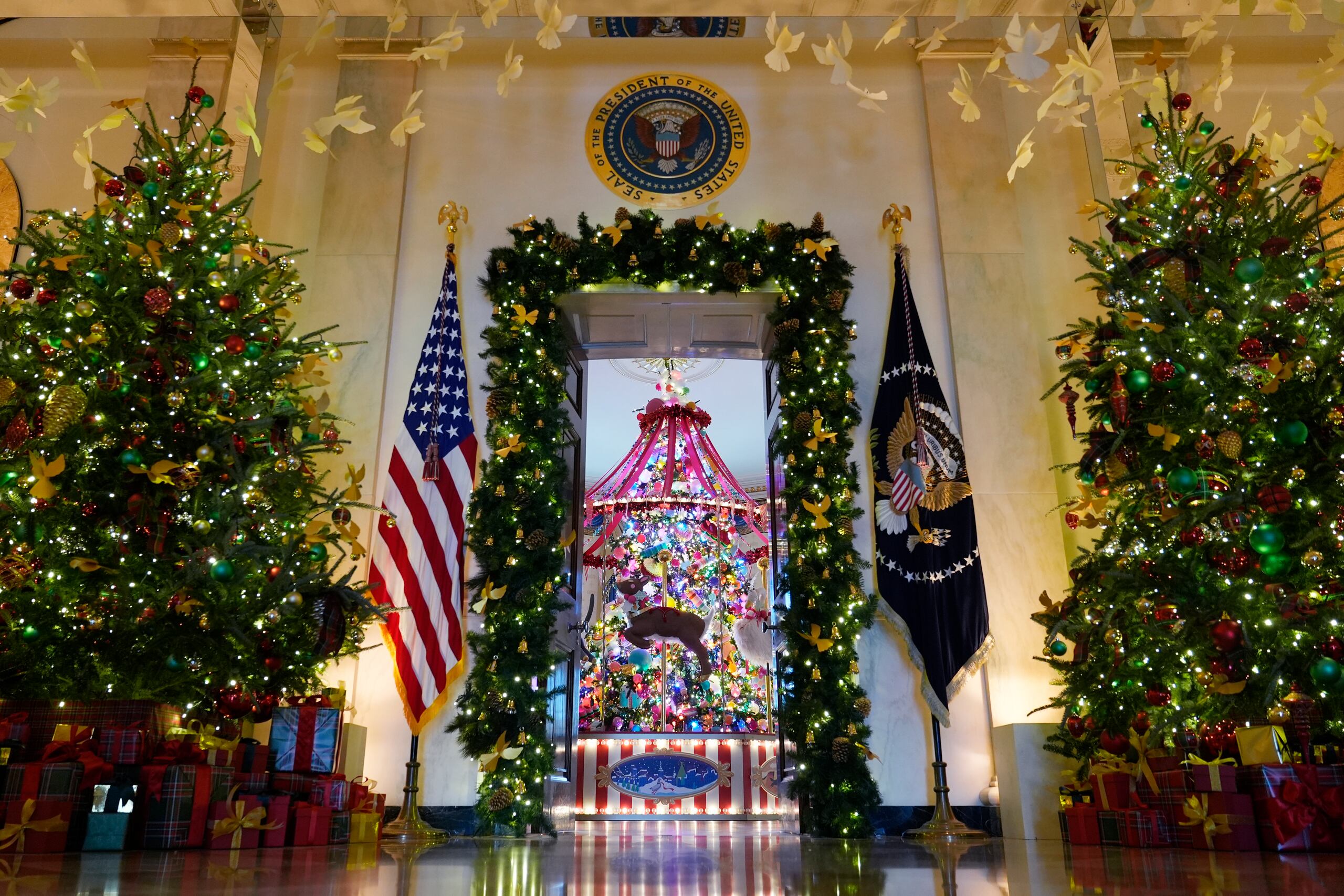 Árboles navideños lucen en el marco de la entrada del Pasillo Cruzado hacia el Salón Azul de la Casa Blanca, en Washington, el lunes 2 de diciembre de 2024. (AP Foto/Susan Walsh)