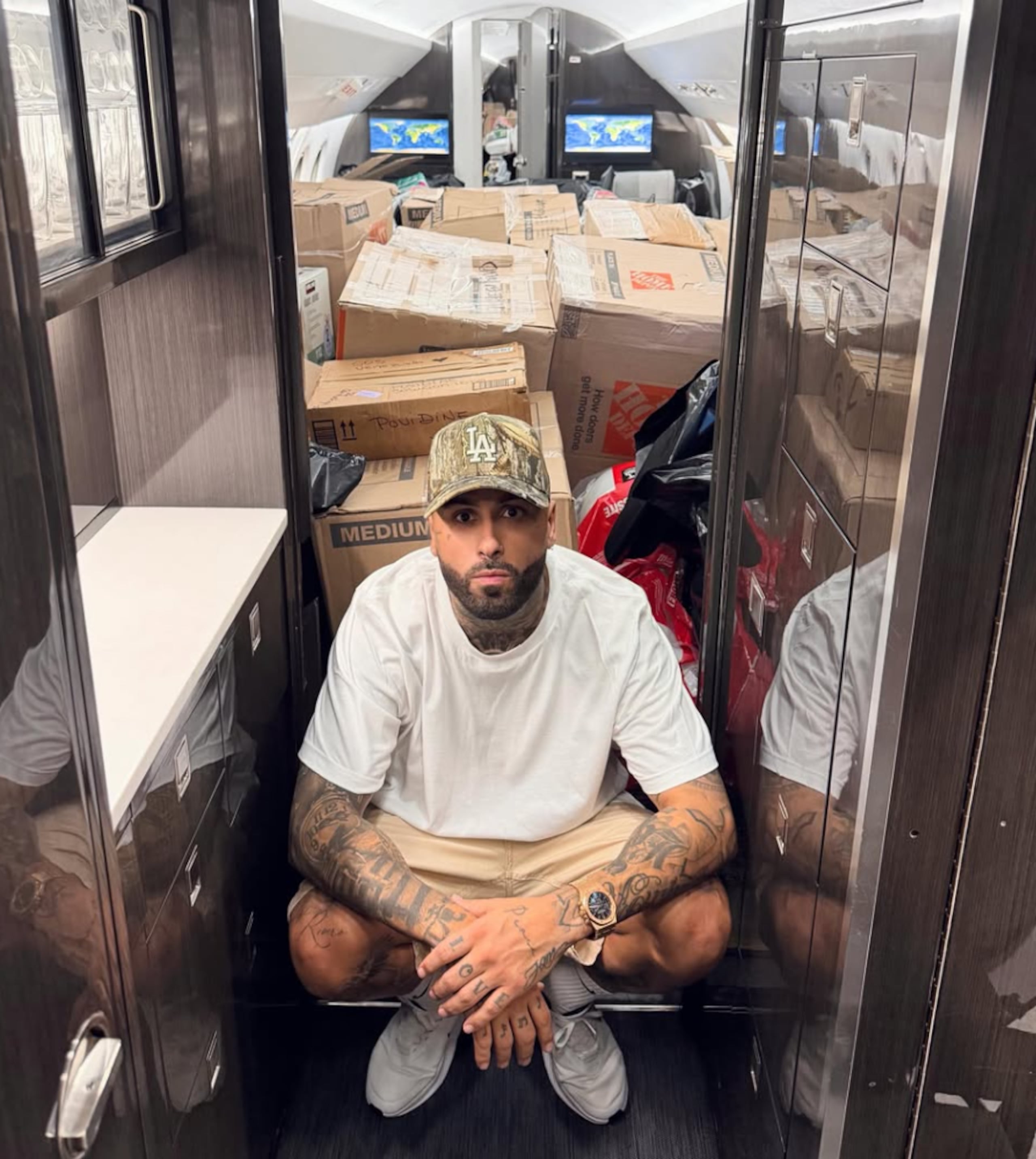 El artista urbano Nicky Jam posa frente a la ayuda que trasladó este miércoles en su avión hacia Venezuela.