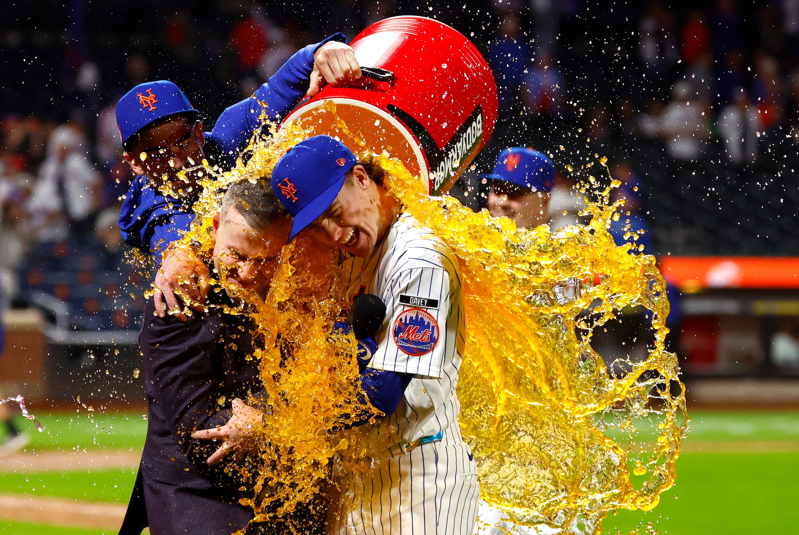 Carson Benge, a la derecha, abraza al narrador Steve Gelbs mientras es bañado con Gatorade tras romper el récord de hits como novato de los Mets.