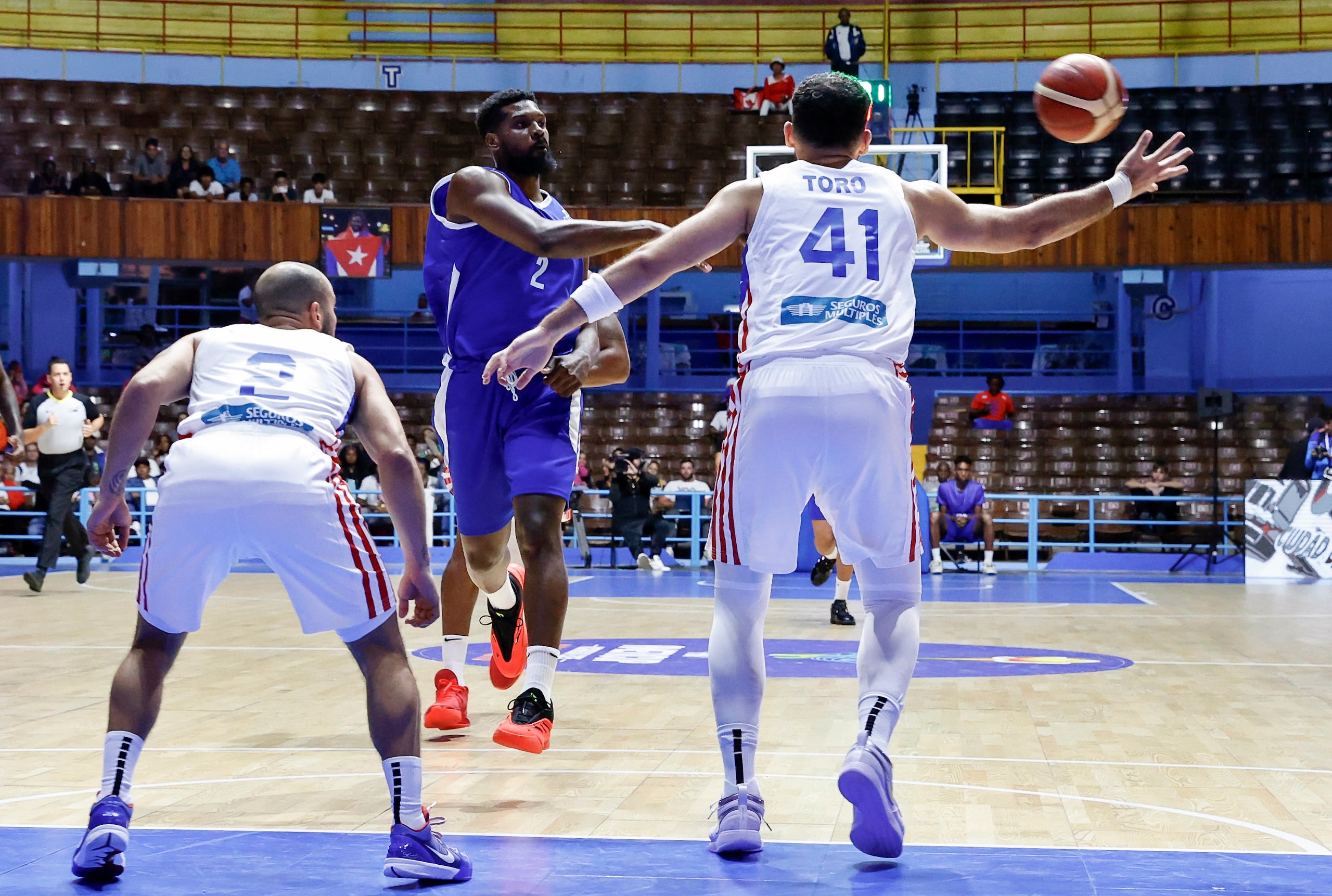 Yoanki Mensia, de Cuba, pase el balón frente a la defensa de Puerto Rico en una de las ventanas clasificatorias al AmeriCup 2025, celebrada en el Coliseo de la Ciudad Deportiva, en La Habana, Cuba.