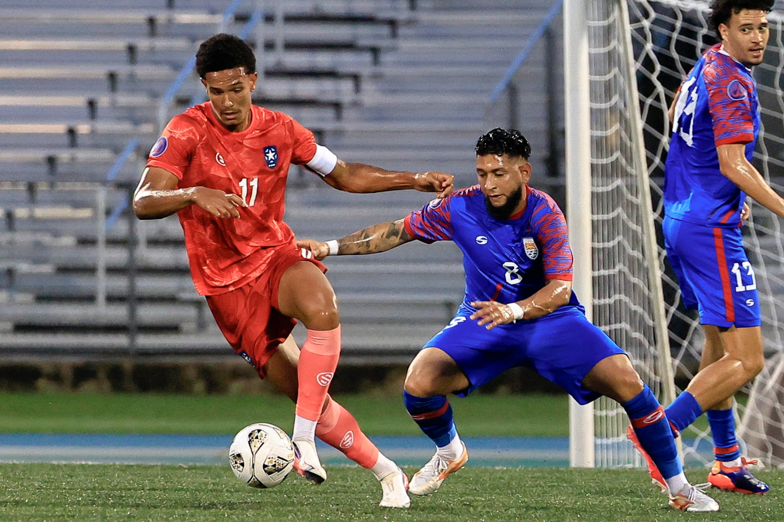 Leandro Antonetti (11) de Puerto Rico disputa un balón con Jordan Bonilla de las Islas Caimán en un partido de la Liga de Naciones Concacaf.