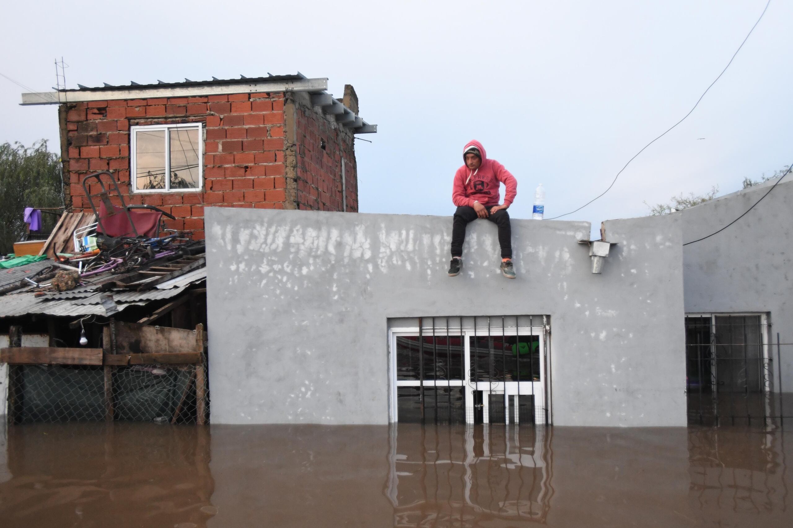 Una persona observa una inundación desde el techo de una vivienda este sábado, en Campana, Buenos Aires (Argentina). EFE/ STR