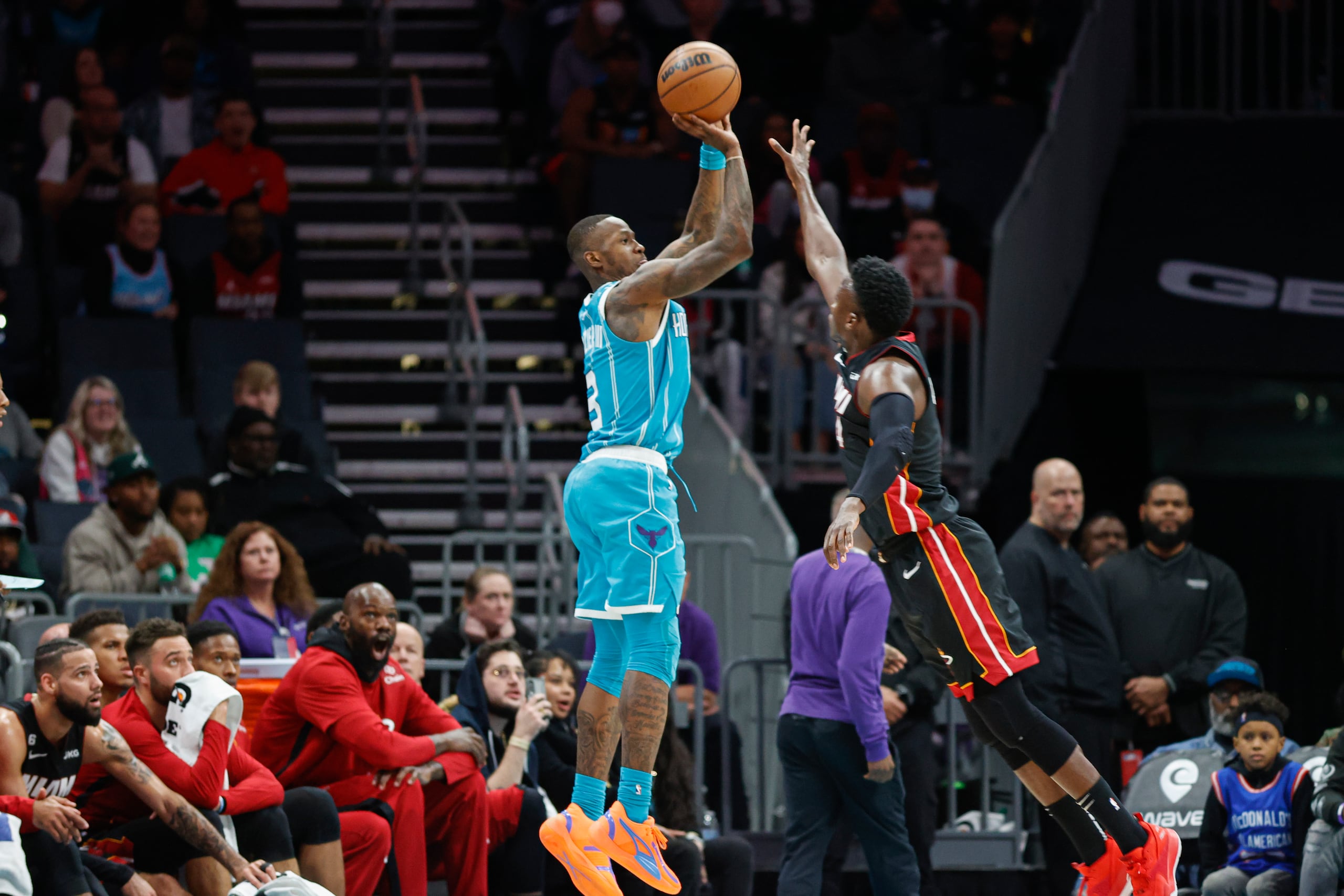El base de los Hornets de Charlotte, Terry Rozier, lanza sobre el base del Heat de Miami, Victor Oladipo, durante la segunda mitad del partido de la NBA en Charlotte, Carolina del Norte, el domingo 29 de enero de 2023. (AP Foto/Nell Redmond)