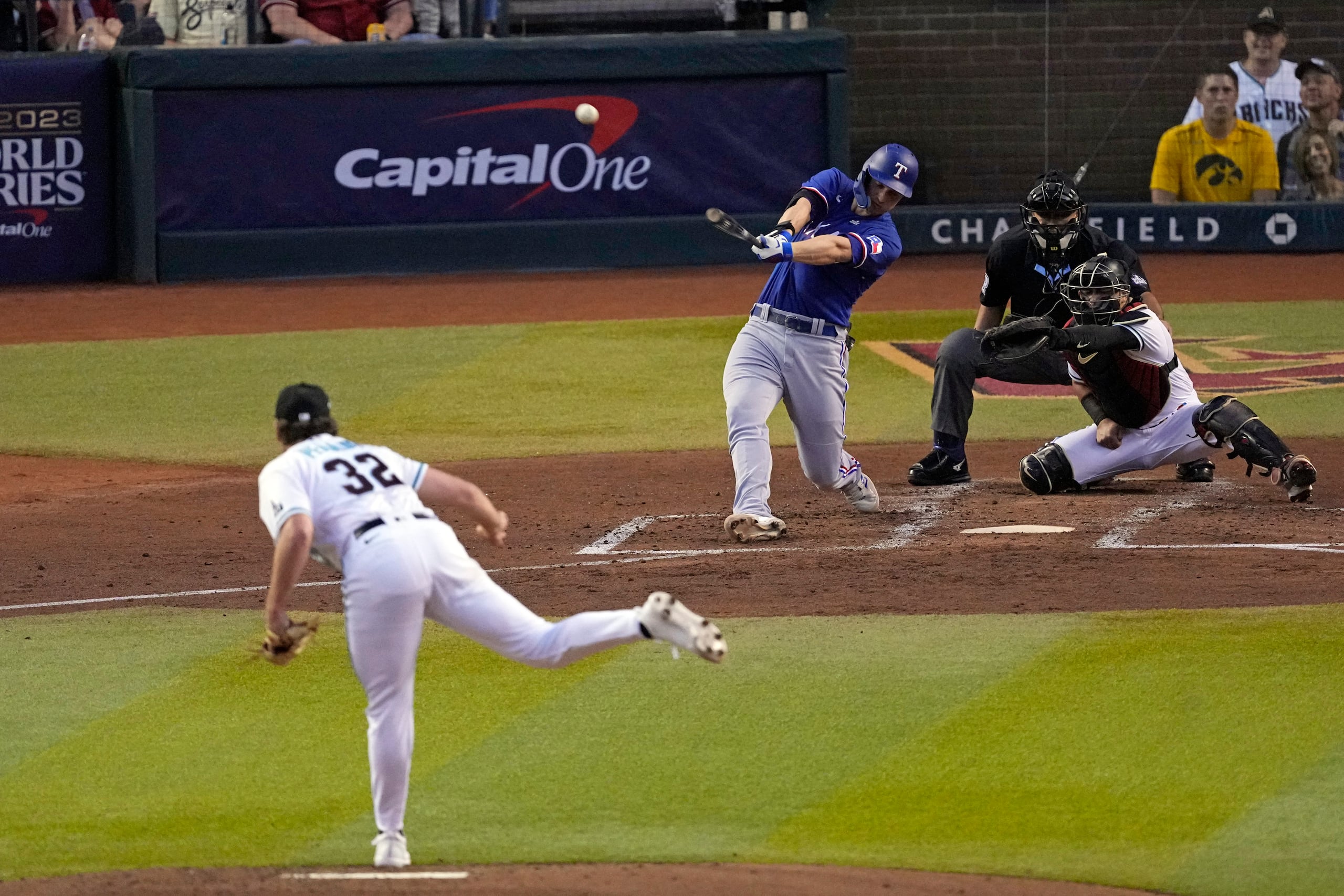 Corey Seager, centro, de los Rangers de Texas, batea un cuadrangular de dos carreras frente al abridor de los Diamondbacks de Arizona, Brandon Pfaadt (32), durante la tercera entrada del Juego 3 de la Serie Mundial, el lunes 30 de octubre de 2023, en Phoenix. (AP Foto/Ross D. Franklin)
