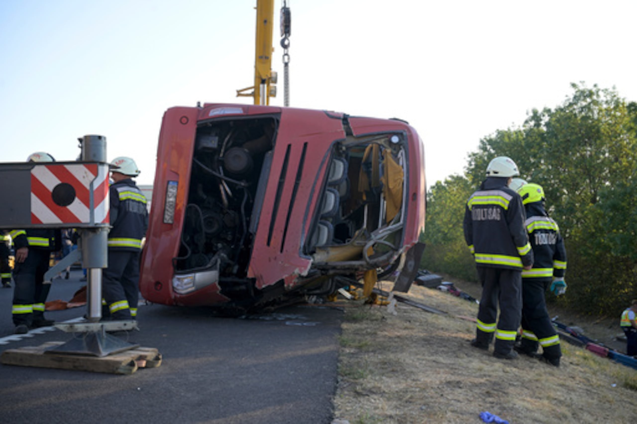 Los servicios de emergencia acuden al lugar del accidente después de que un autobús de pasajeros se saliera de la carretera y volcara en una zanja junto a una autopista entre Mezokeresztes y Mezonagymihaly, en Hungría, el domingo 16 de agosto de 2026. (Zoltan Mathe/MTI vía AP)