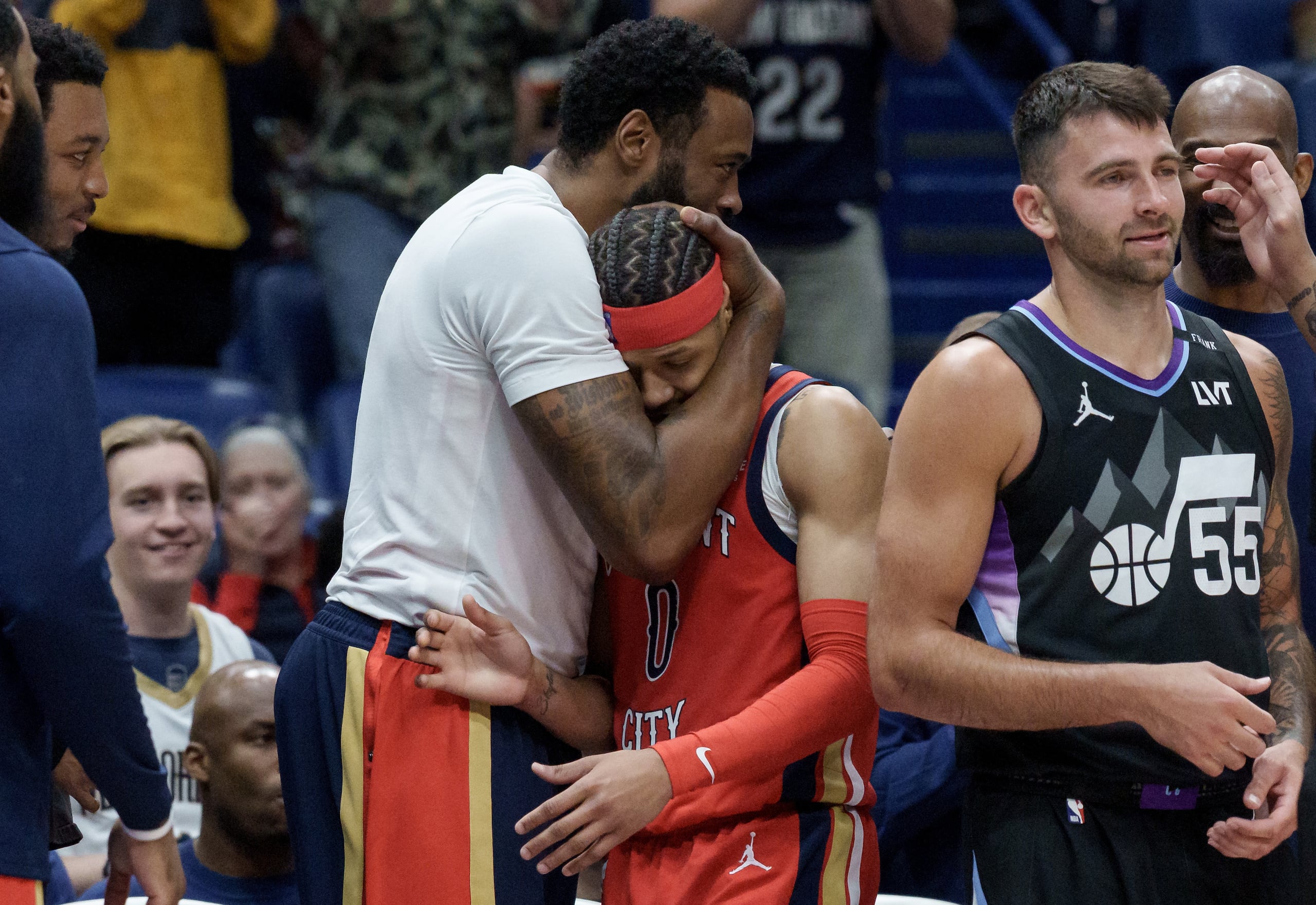 El pívot de los Pelicans de Nueva Orleans, DeAndre Jordan, abraza al base de los Pelicans, Jeremiah Fears (0), durante la segunda mitad luego de que Fears anotara 40 puntos contra el Jazz de Utah, incluyendo al base de los Jazz, John Konchar (55), durante un partido de baloncesto de la NBA en Nueva Orleans, el martes 7 de abril de 2026. (AP Foto/Matthew Hinton)