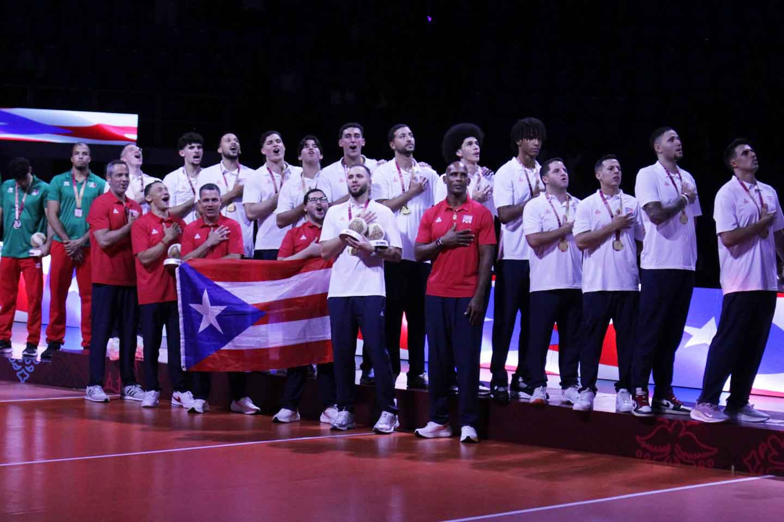 La Selección Nacional de Voleibol de Puerto Rico escucha la entonación del himno nacional tras su premiación.