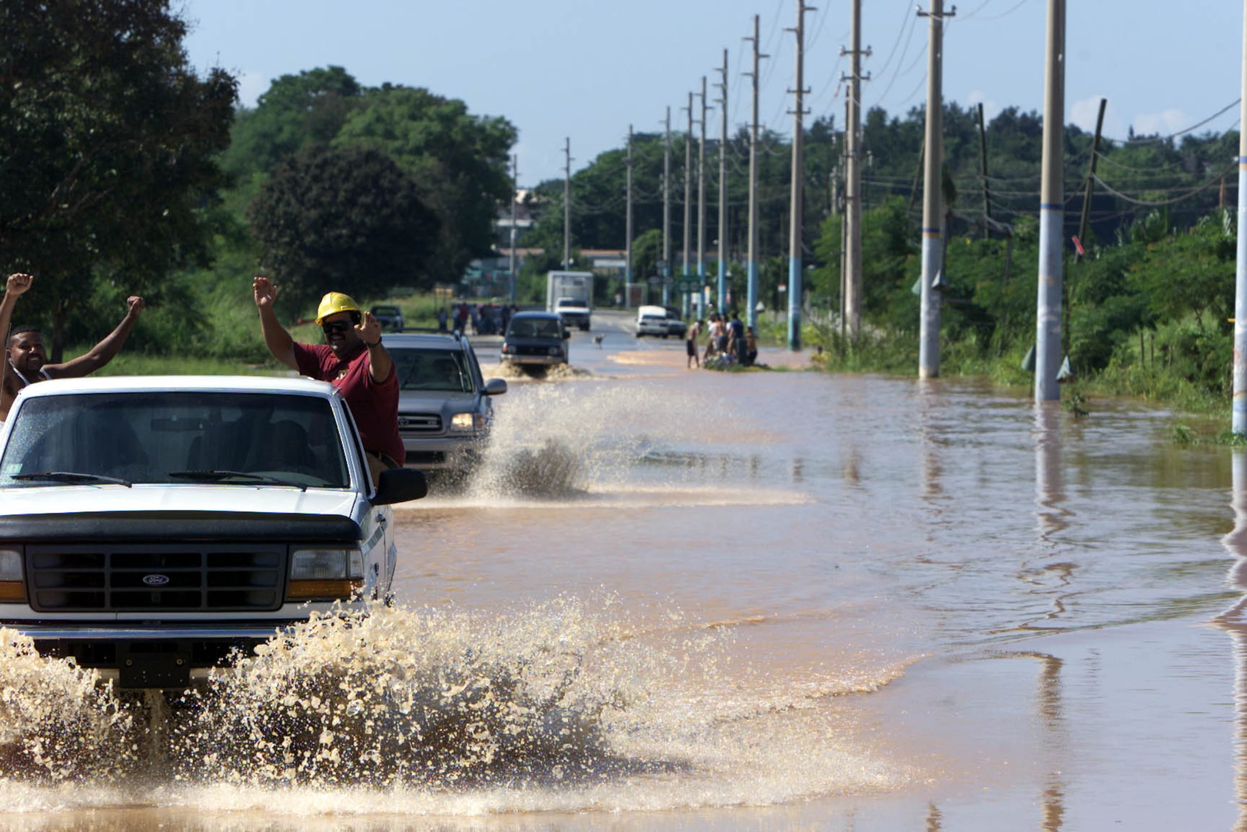 Conductores pasan por una zona inundada. (Archivo / GFR Media)