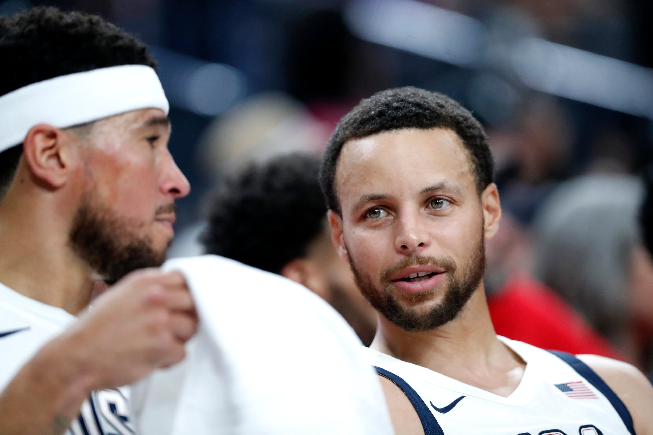 Devin Booker y Stephen Curry conversan durante un periodo del juego de exhibición del miércoles ante Canadá.