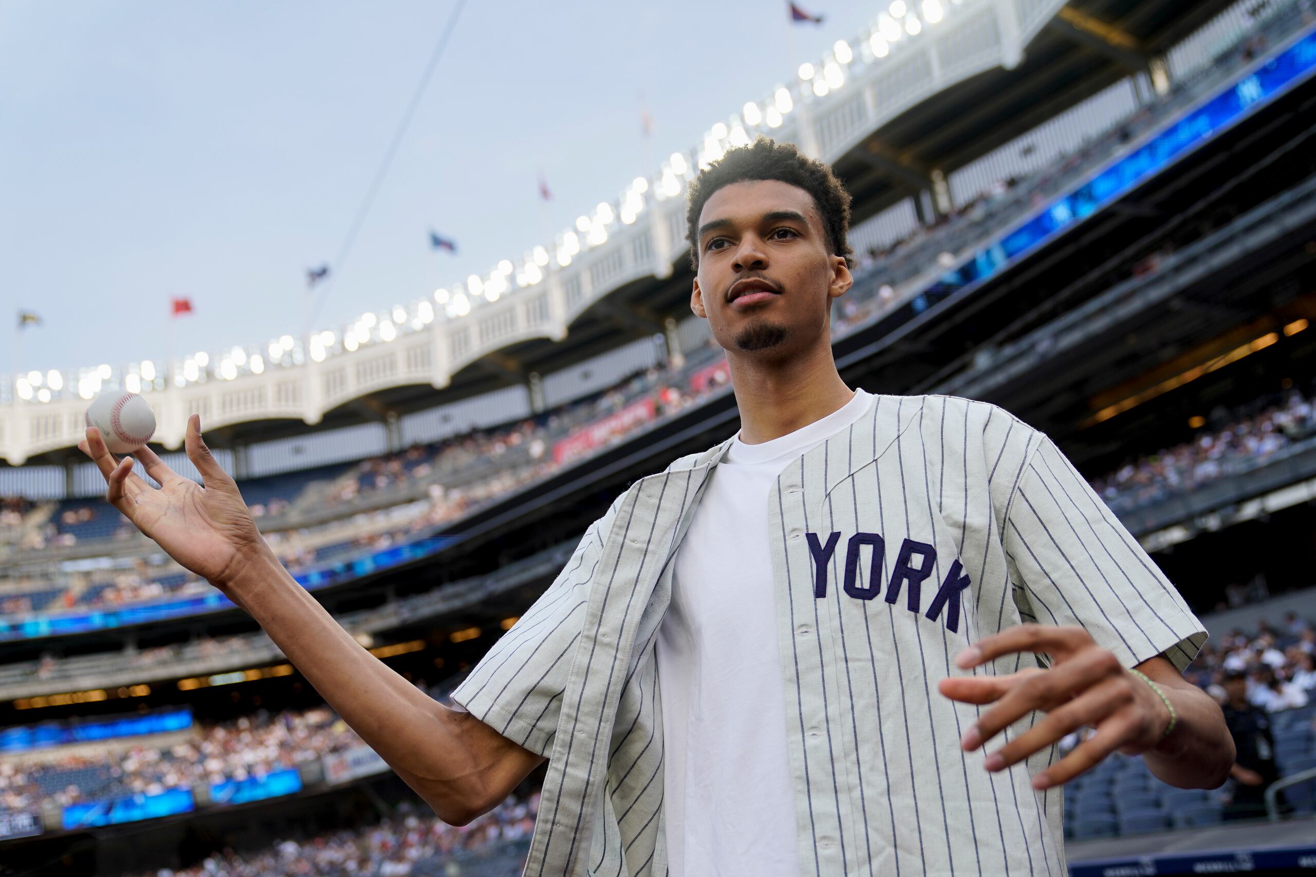 El basquetbolista francés Victor Wembanyama realizó anoche el primer lanzamiento del juego entre los Yankees y los Mariners en Nueva York.