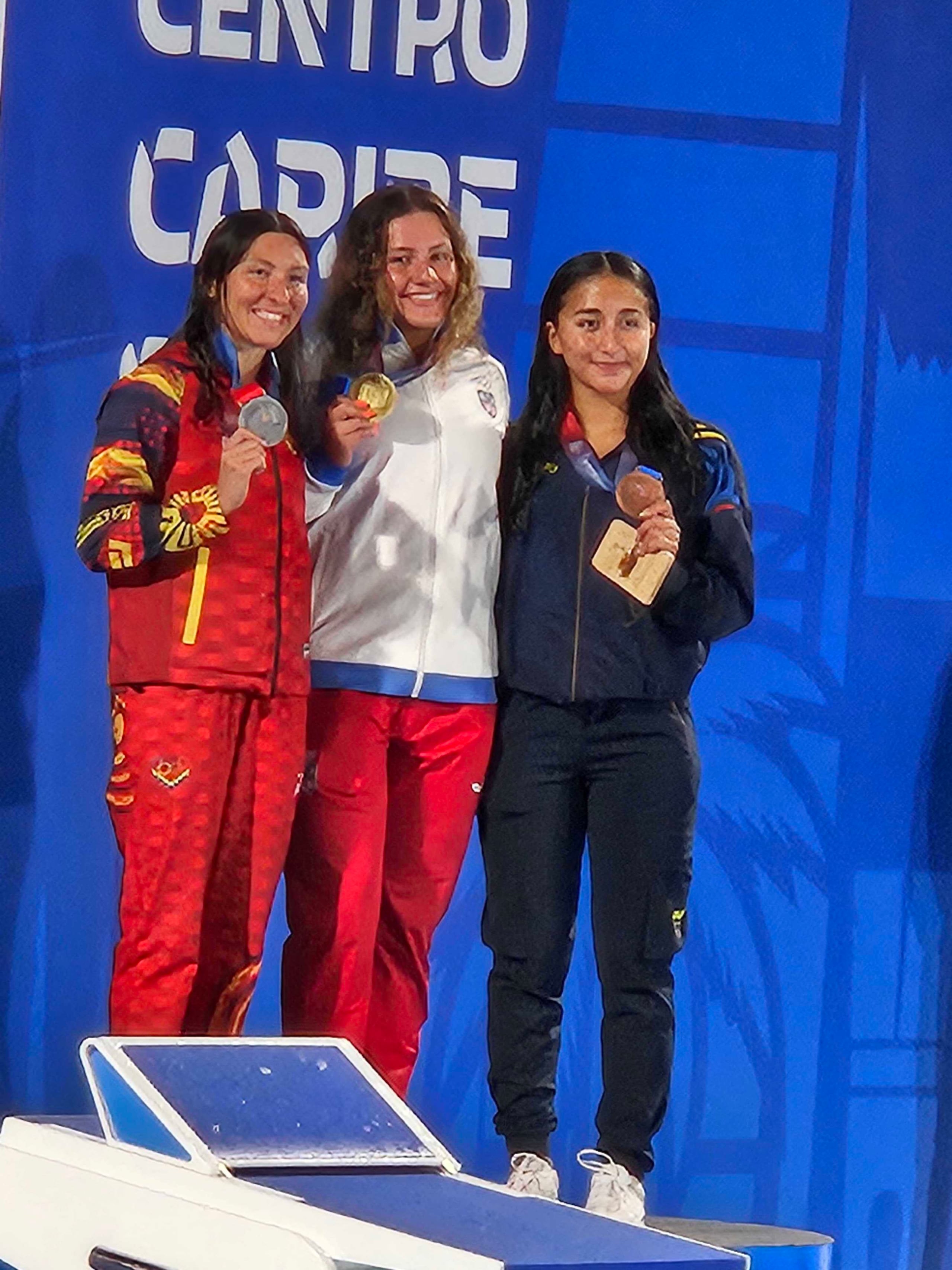Lucianna Gutierrez, al centro, posa con su medalla de oro en los 800 metros libres.