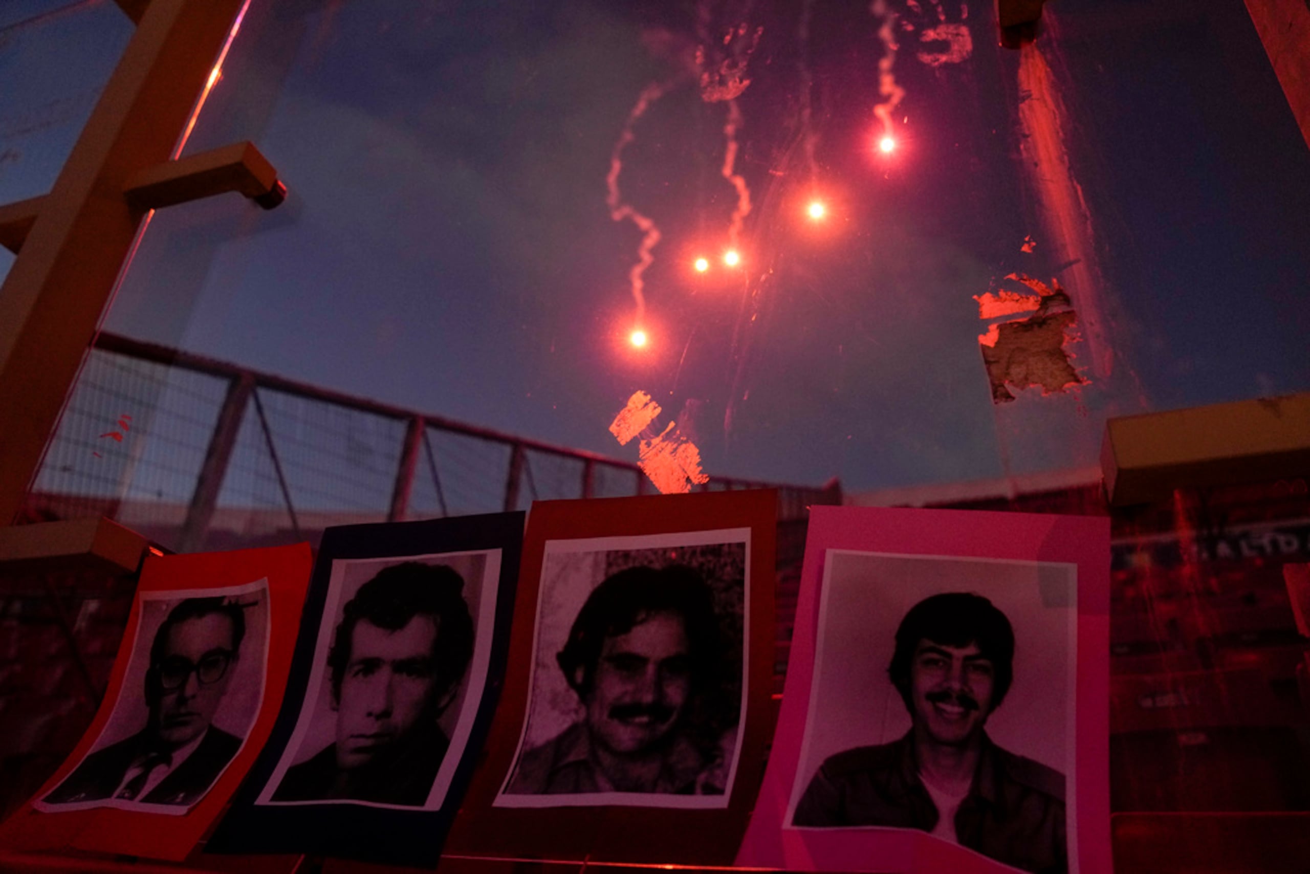 Fuegos artificiales iluminan el cielo ante un despliegue de retratos de personas que fueron ejecutadas y desaparecidas en los primeros días de la dictadura militar del general Augusto Pinochet.