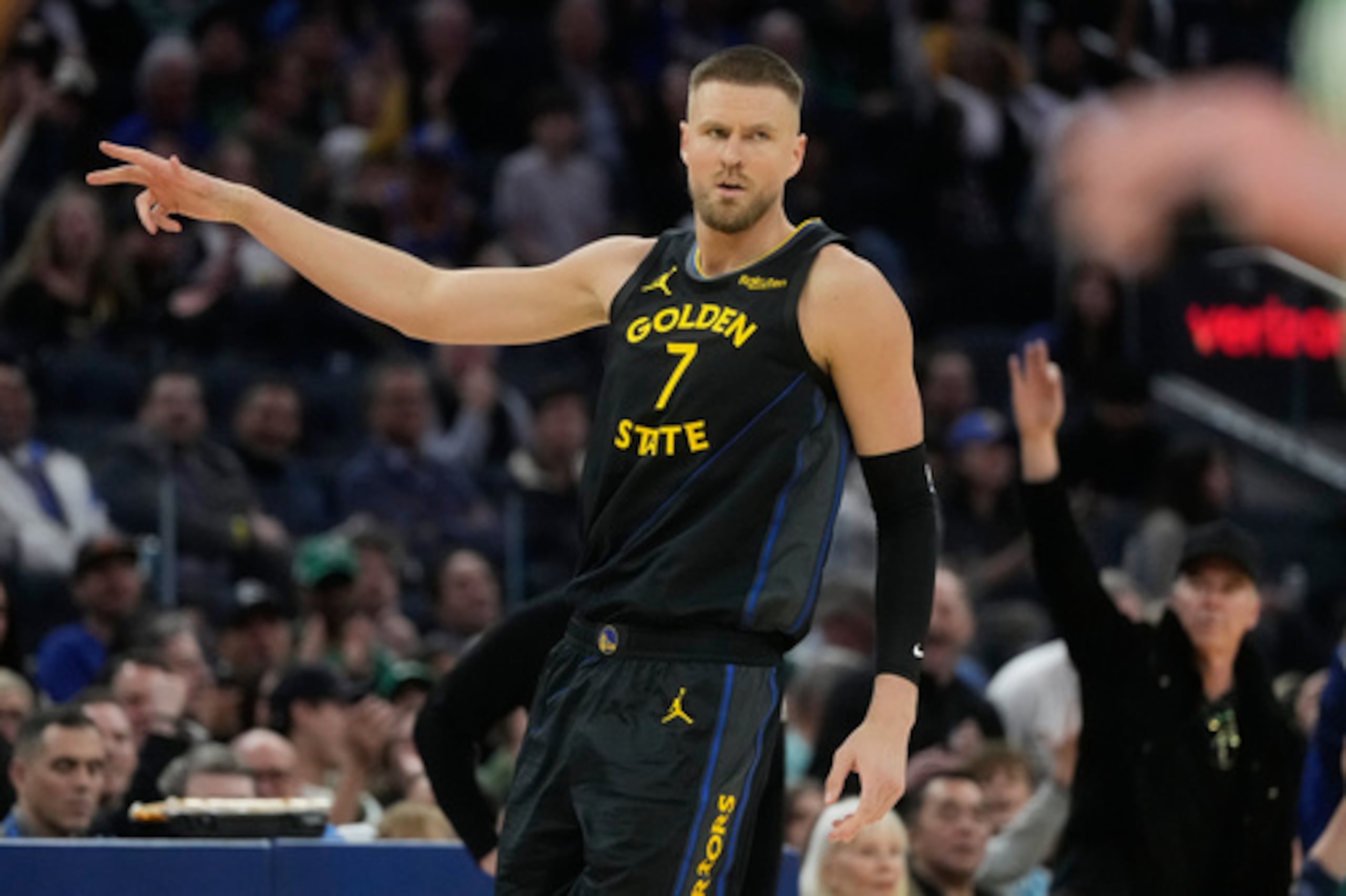 El pívot de los Golden State Warriors Kristaps Porziņģis (7) gesticula tras encestar una canasta de 3 puntos durante la primera mitad de un partido de baloncesto de la NBA contra los Boston Celtics en San Francisco, el jueves 19 de febrero de 2026. (AP Photo/Jeff Chiu)