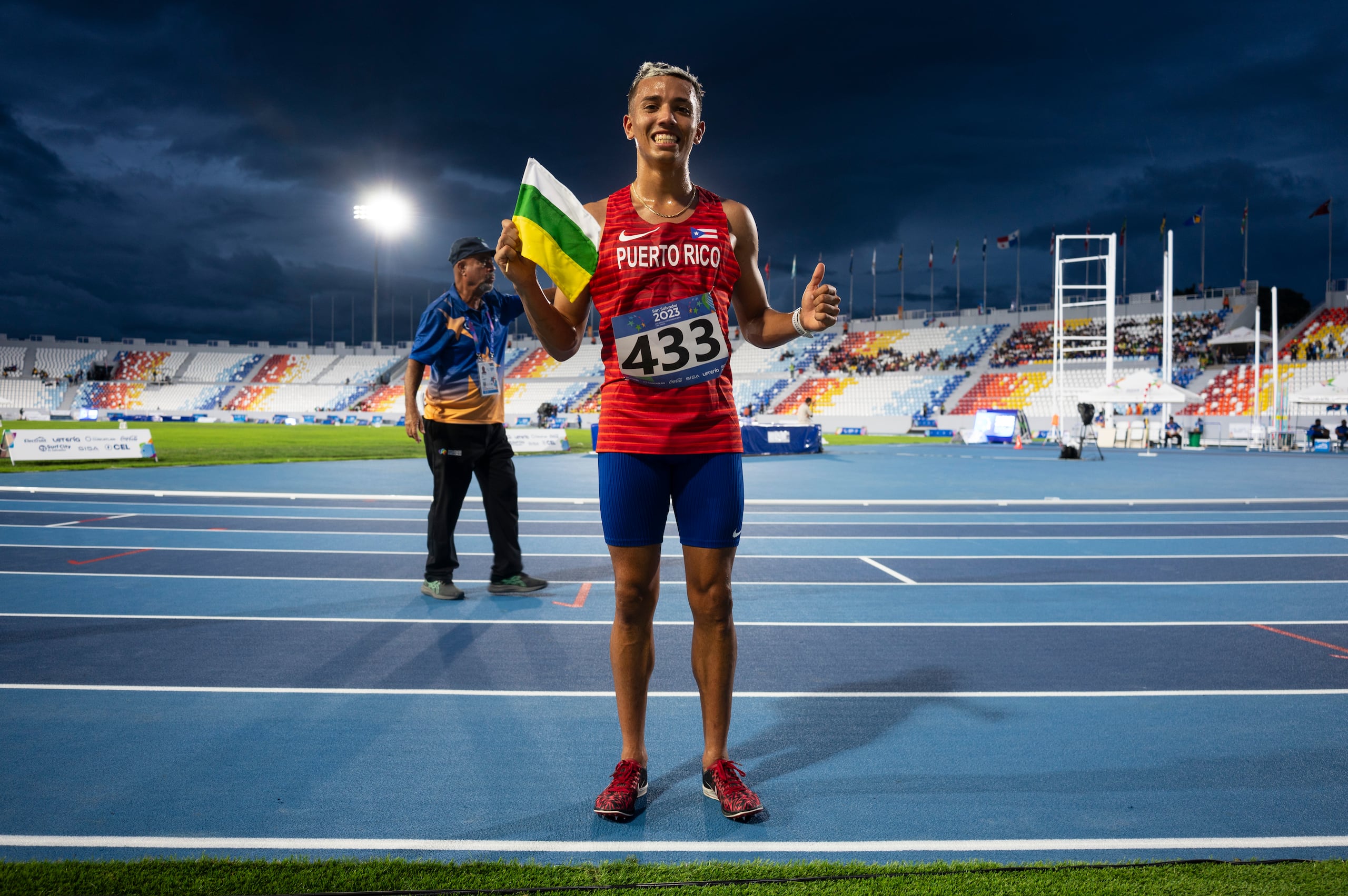 El medallista de oro, Héctor Pagán posa con la bandera de Barranquitas en el escenario de los Centroamericanos.