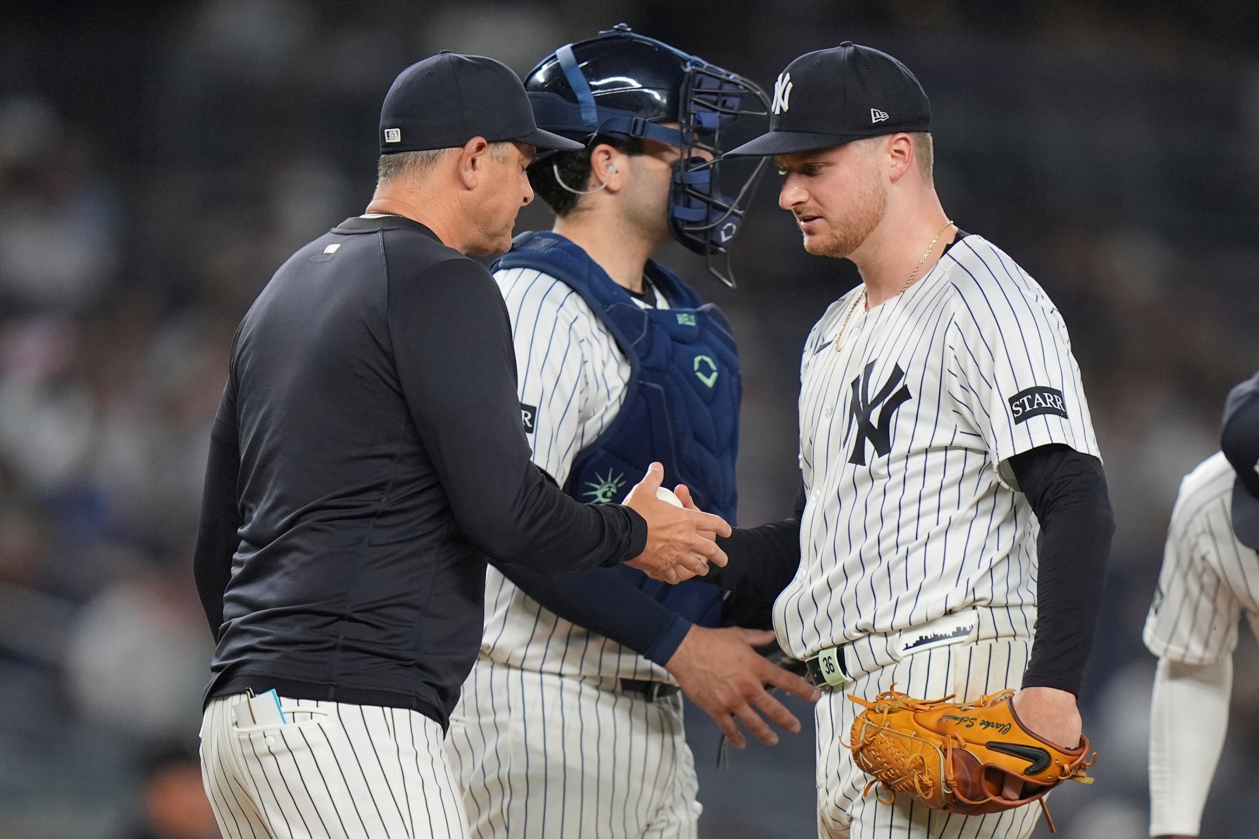 El pitcher Clarke Schmidt de los Yankees de Nueva York entrega la pelota al mánager Aaron Boone al ser relevado en un juego, el 4 de junio de 2025, en Nueva York. (AP Foto/Frank Franklin II)