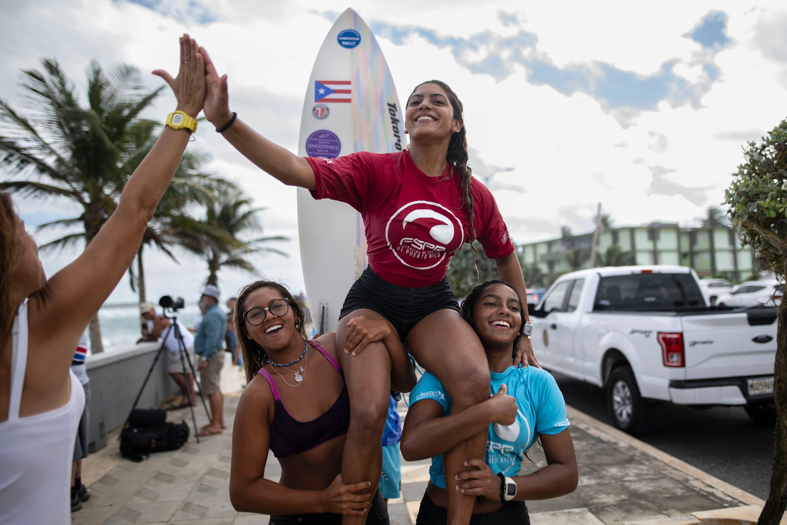 Miamar sale del agua cargada por su hermana Sinaí (a la derecha) y otra amiga luego de ganar la categoría de 18 años y menos de la cuarta parada del Circuito Nacional de Surfing.
