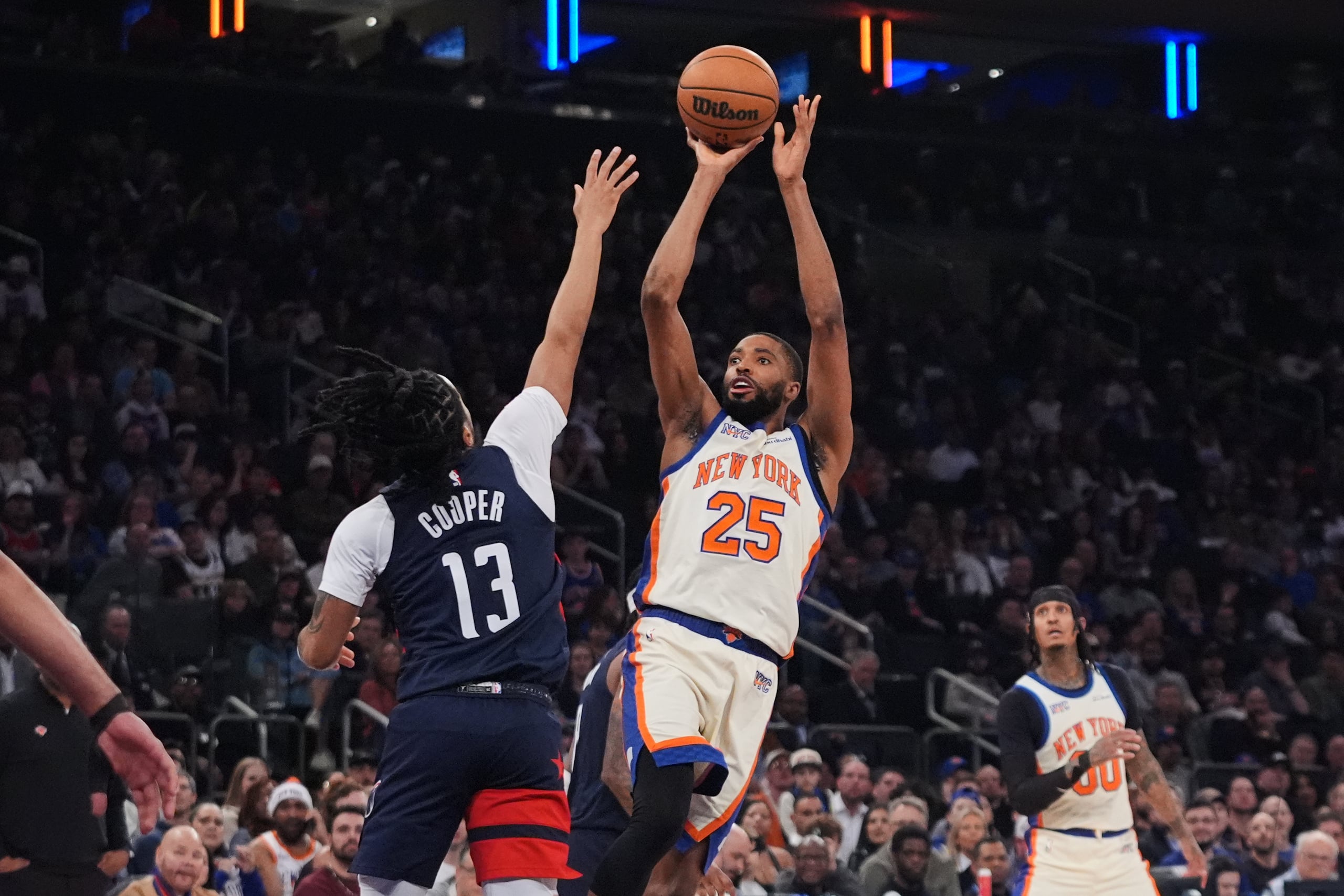 Mikal Bridges (25), de los Knicks de Nueva York, dispara sobre Sharife Cooper (13), de los Wizards de Washington, durante la primera mitad del juego de baloncesto de la NBA, el domingo 22 de marzo de 2026, en Nueva York. (AP Foto/Frank Franklin II)